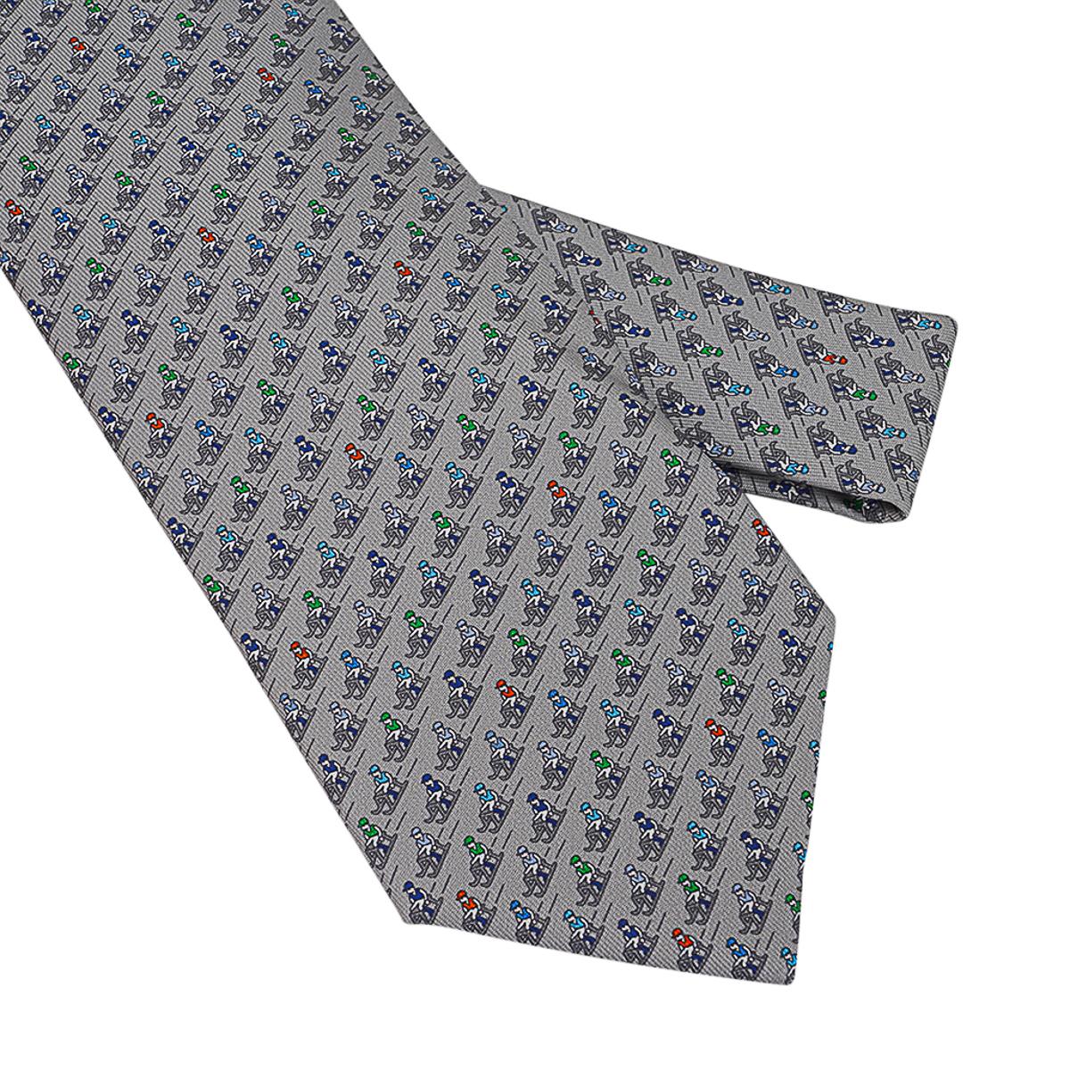 Mightychic offers an Guaranteed authentic Hermes Sliding Jockey Twillbi silk tie featured in Gris, Anthracite and Bleu colorway.
The tail hides the Ex-Libris coachman making a snowman and jockeys downhill sledding!
Designed by Philippe Mouquet.
Hand