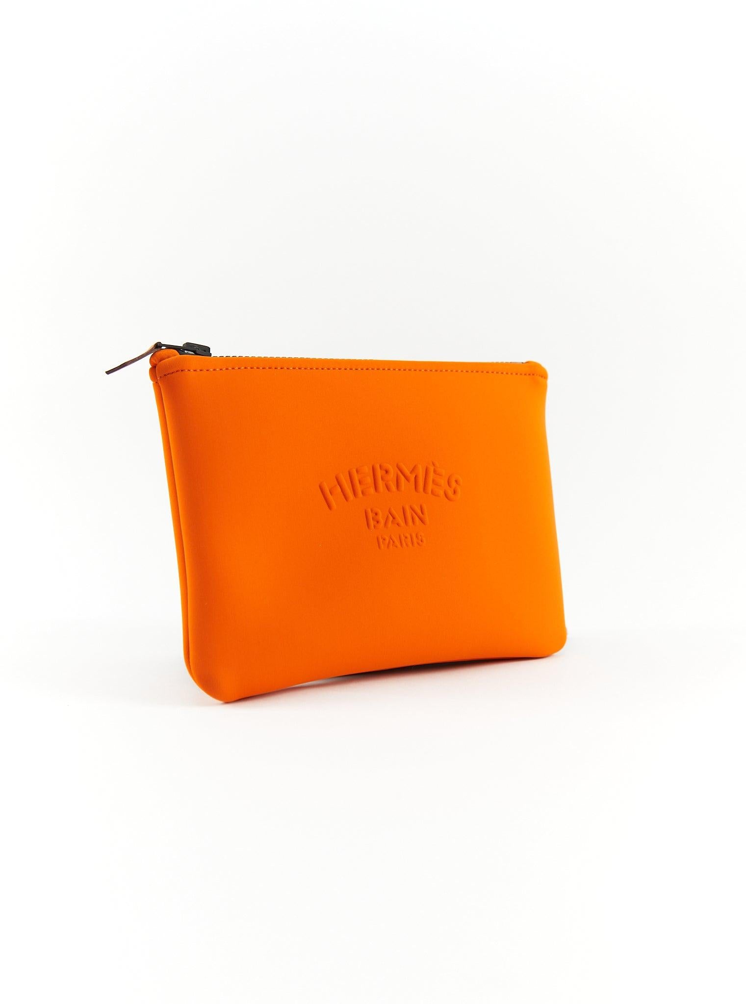 Hermès Neobain Case in Orange

Zip closure with leather pull tab 

80% polyamide and 20% elastane

Small Model 

Dimensions: L 21 x H 15 cm

Made in France