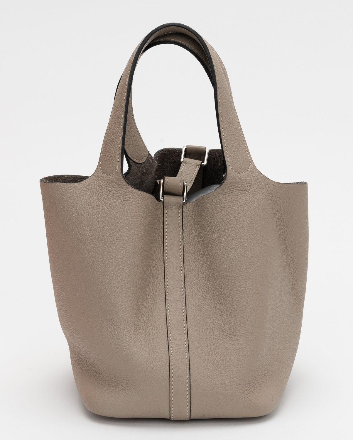 Picotin tote bag from Hermès Pre-Owned featuring gris tortorelle, Taurillon Clemence leather, two flat top handles and metal feet. It's in excellent condition nearly perfect. The handles drop is 6' and the bag comes with the original box.