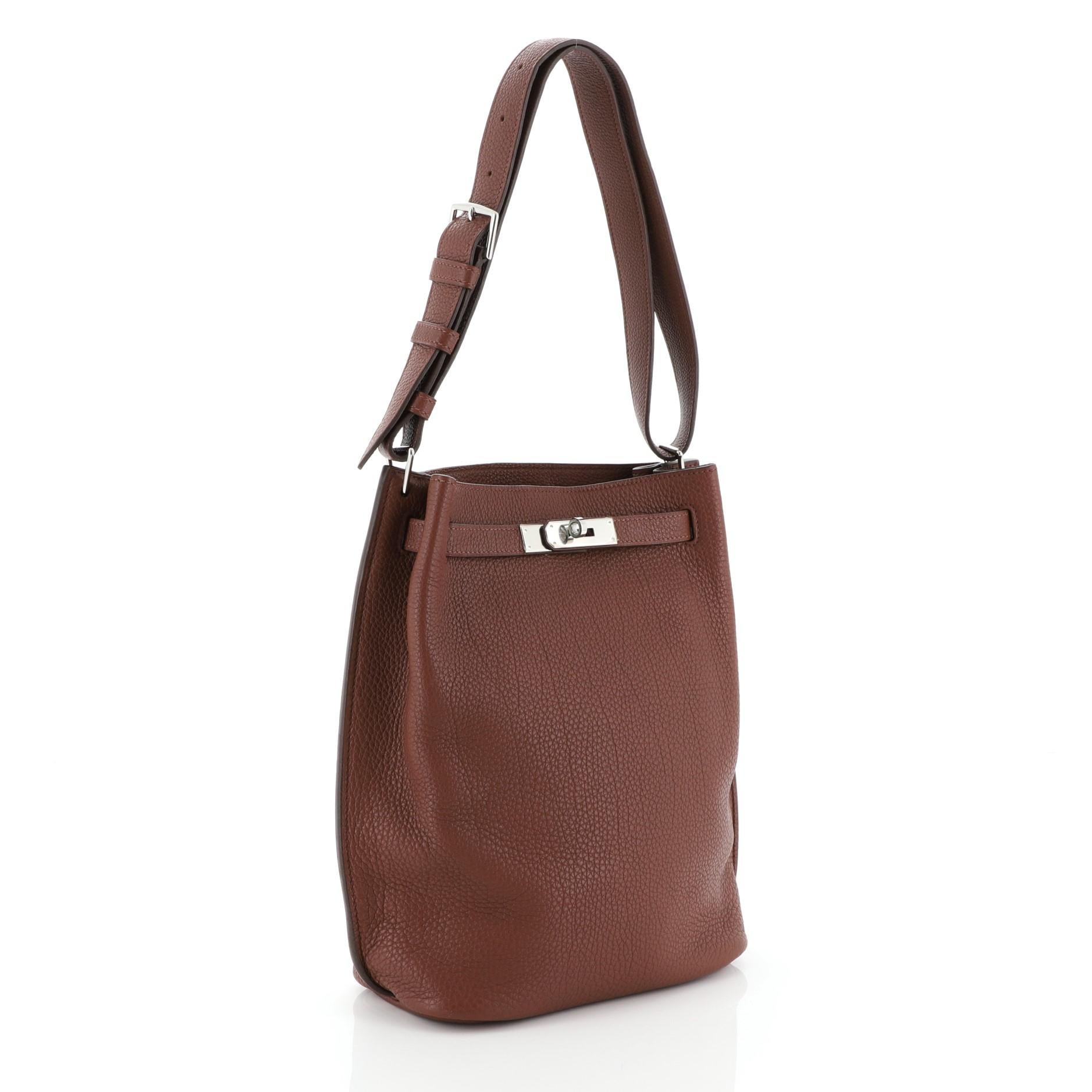This Hermes So Kelly Handbag Togo 22, crafted from Marron d'Inde brown Togo leather, features an adjustable single looped handle and palladium hardware. Its turn-lock closure opens to a Marron d'Inde brown Chevre leather interior with side zip and