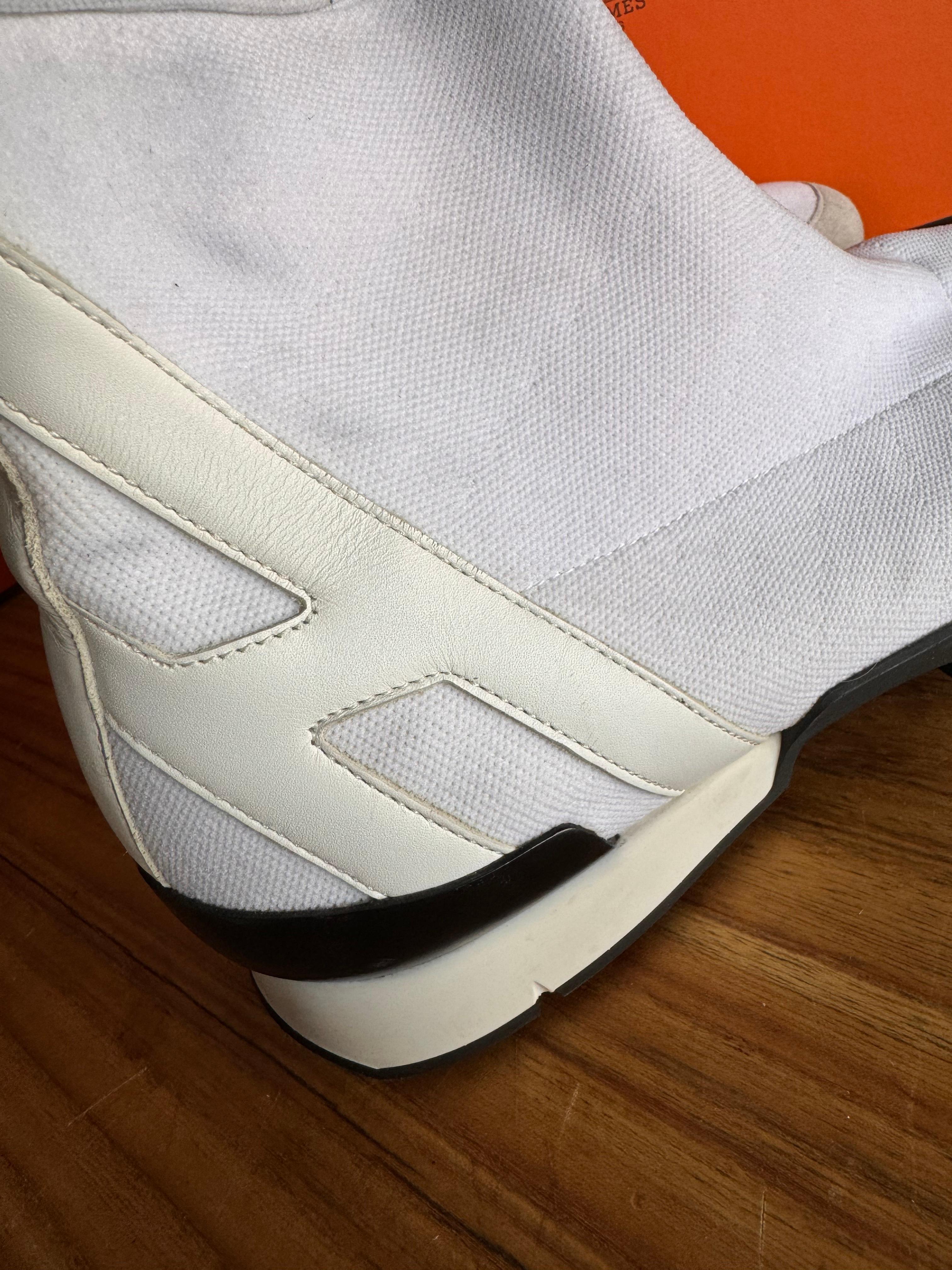 Der Hermès Socks Sneaker ist ein Meisterwerk des zeitgenössischen Schuhdesigns. Diese von der renommierten Luxusmarke Hermès kreierten Sneaker definieren die Grenzen der lässigen Eleganz neu. Mit ihrer makellosen weißen Farbe strahlen sie Reinheit