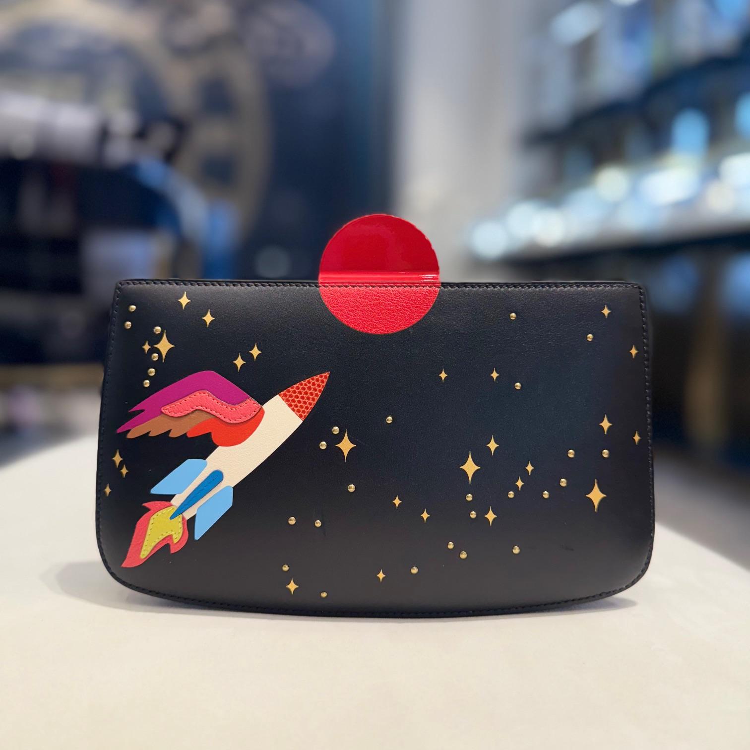 Jewell Aficionado propose un Sac à Malice Hermès Space en Noir et Multicolore Monsieur avec cuir de lézard qui est un chef d'œuvre d'audace et d'innovation. La couleur Noir offre une base noire profonde et sophistiquée, tandis que les accents
