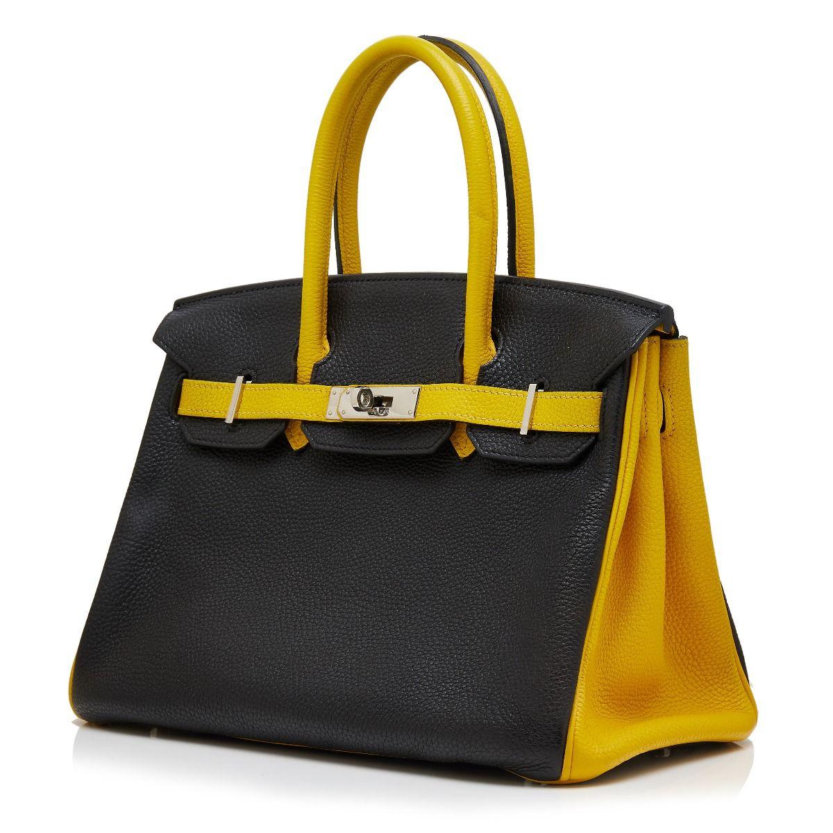 Adding a twist to the traditional Hermès Birkin, this bi-colour bag was specially made to order and showcases a bold black togo leather exterior, which is offset by contrasting bright yellow top-handles, piping and belt arms and accented by