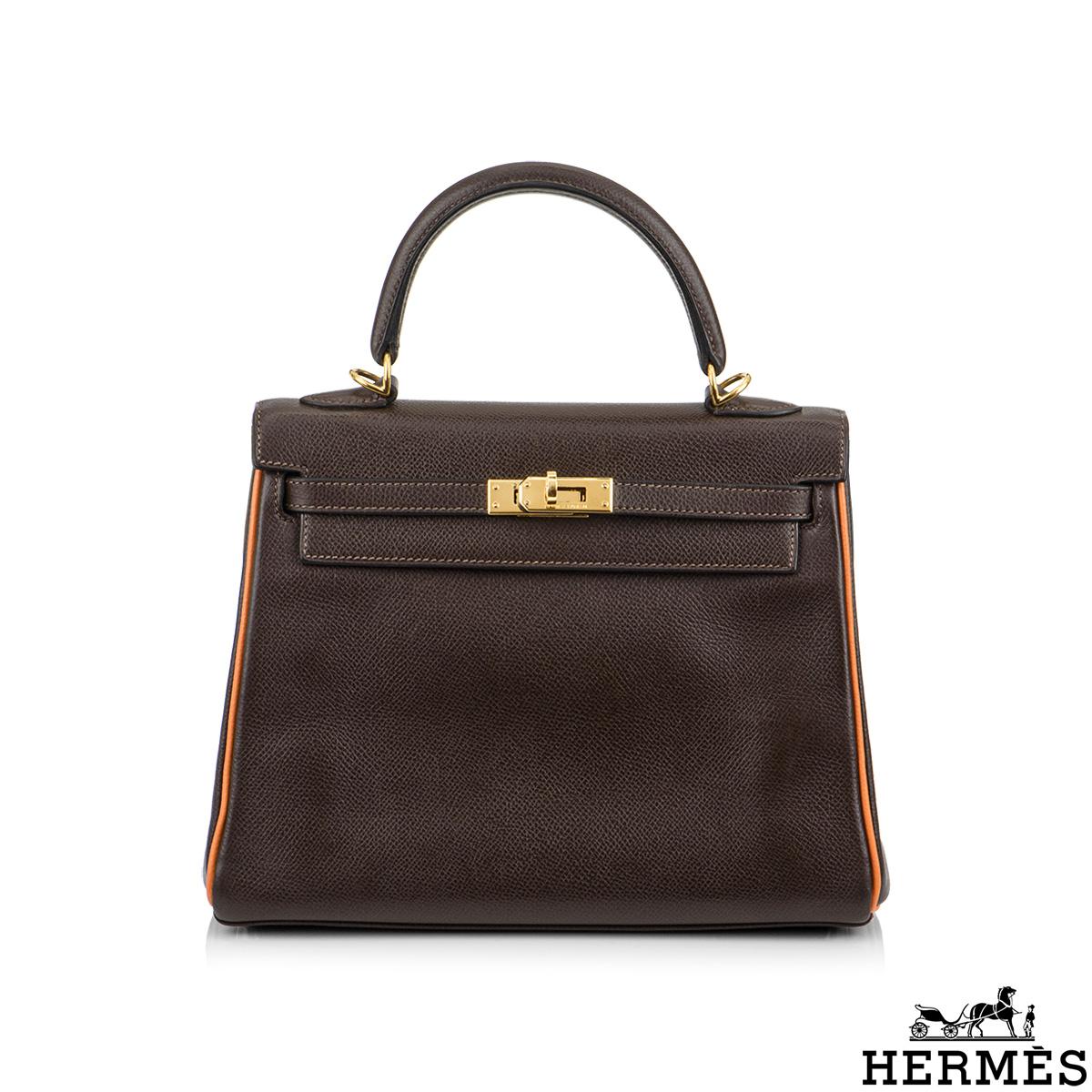 A beautiful vintage Hermès Kelly 25cm Bi colour Handbag. The chocolate brown colour is complimented with orange piping and gold hardware. The exterior of this Kelly features a retourne style in chocolate brown leather. It has a front toggle closure,