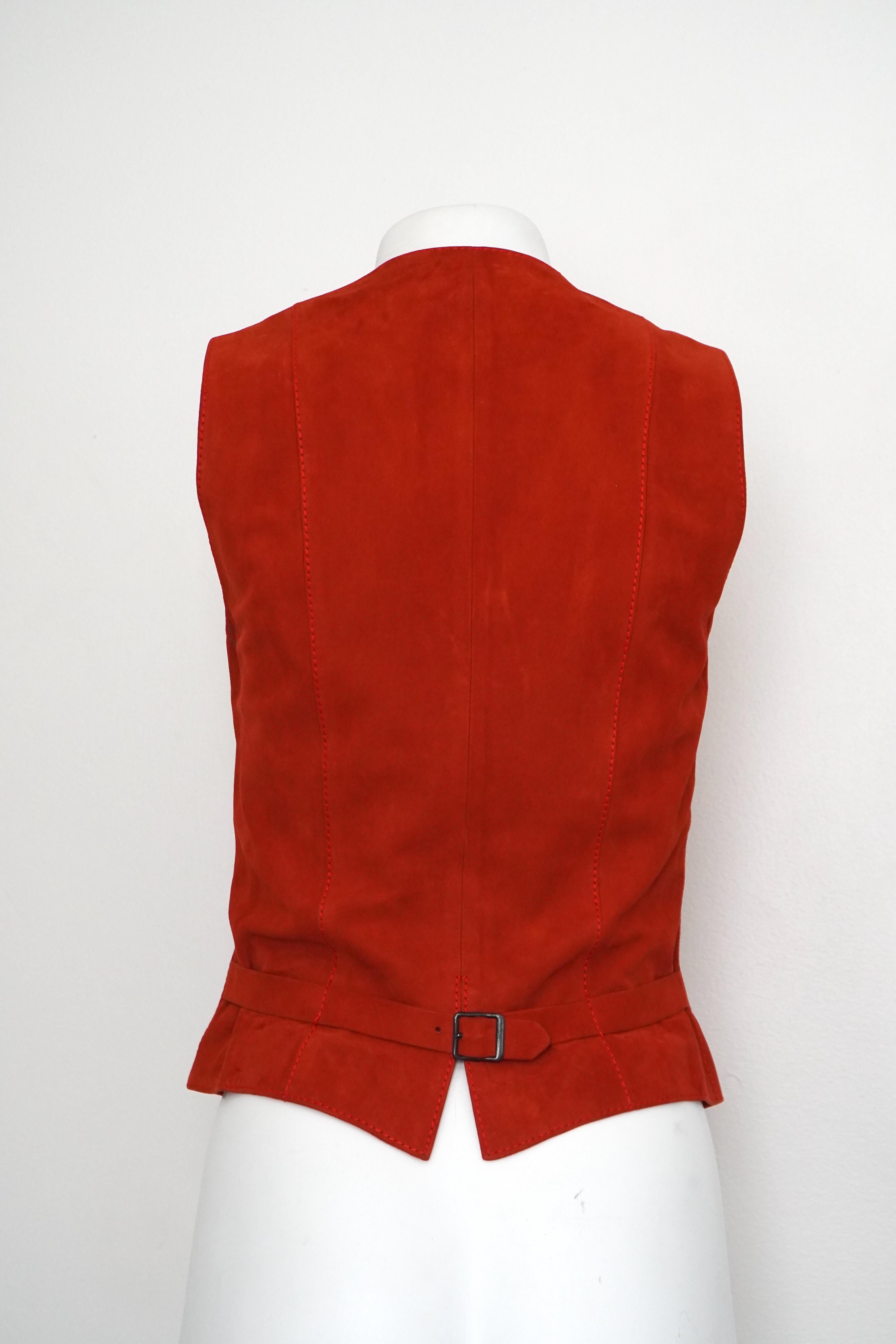 This beautiful Hermès Sport Suede Vest has a 5 button closure and has a belt adjustment in the back. We have it in a vibrant burnt orange color in size EU 40. Also it has two faux pockets in the front. This piece is still in great condition with
