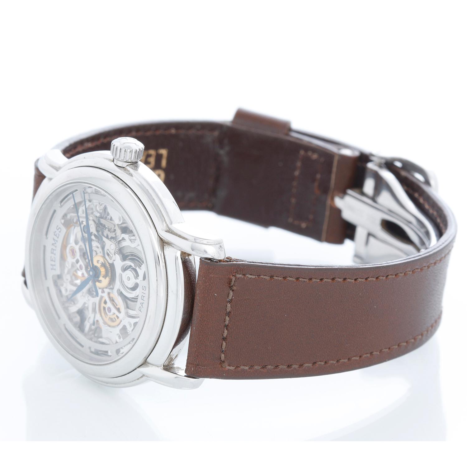 Hermes Edelstahl Sesam TGM Skelett Uhr Ref. SM1.710 - Automatischer Aufzug. Gehäuse aus rostfreiem Stahl (36 mm). Silbernes, skelettiertes Zifferblatt mit blauen Zeigern. Schwarzes Armband mit Hermes-Faltschließe aus Edelstahl. Pre-owned mit