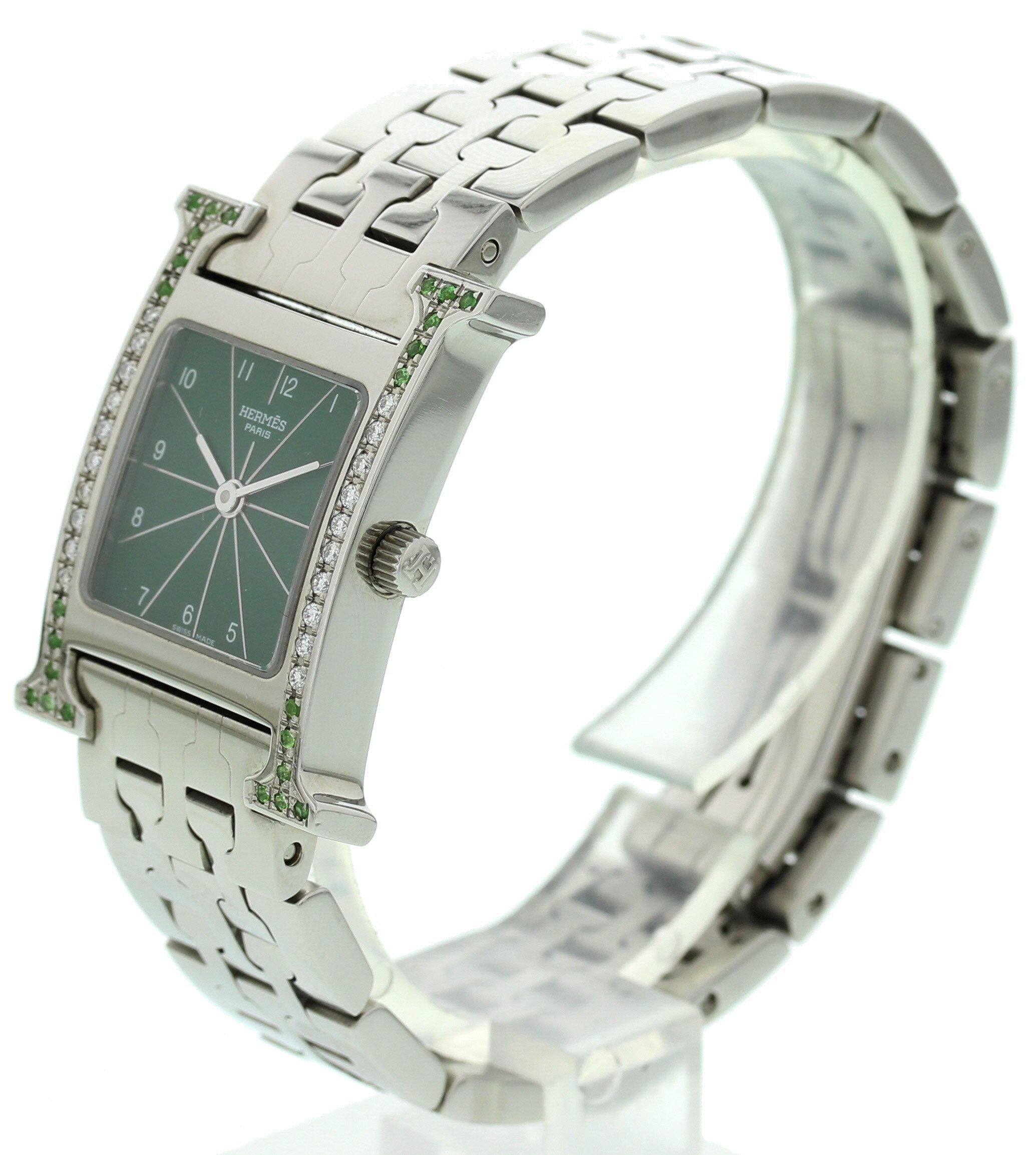 Ladies Hermes HH1.210. 21 mm stainless steel case custom set multi colored diamonds. Dark green dial with steel hands. Stainless steel band with a hidden butterfly clasp. Will fit up to 6.5 inch wrist. Quartz movement. Sapphire crystal.
