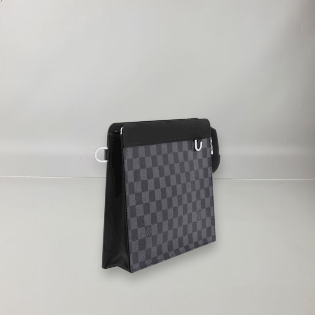 This Standing pouch keeps everyday essentials close at hand. Crafted in Louis Vuitton's signature Damier Graphite canvas, this sleek piece reveals a spacious interior capable of holding a tablet, multiple phones, documents and other small items. It
