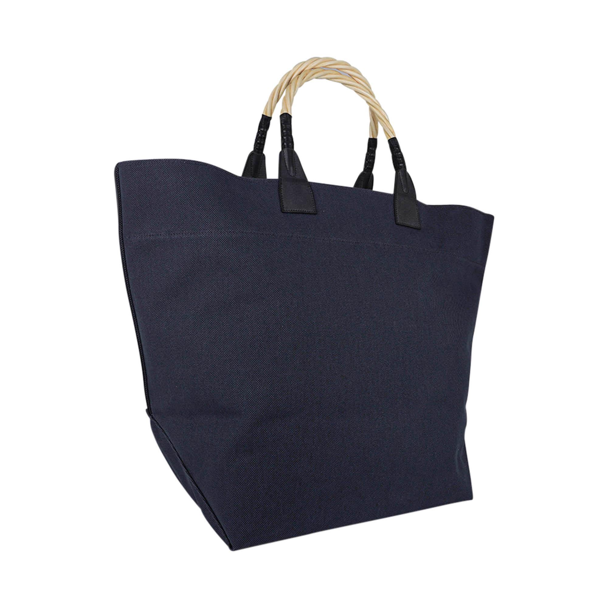 Mightychic offers a Guaranteed authentic limited edition Hermes Steeple Tote bag featured in Marine.
Braided micocoulier (hackberry wood) double handles.
Black leather accents at the handles and on the sides.
Handle leather detail is in the shape of