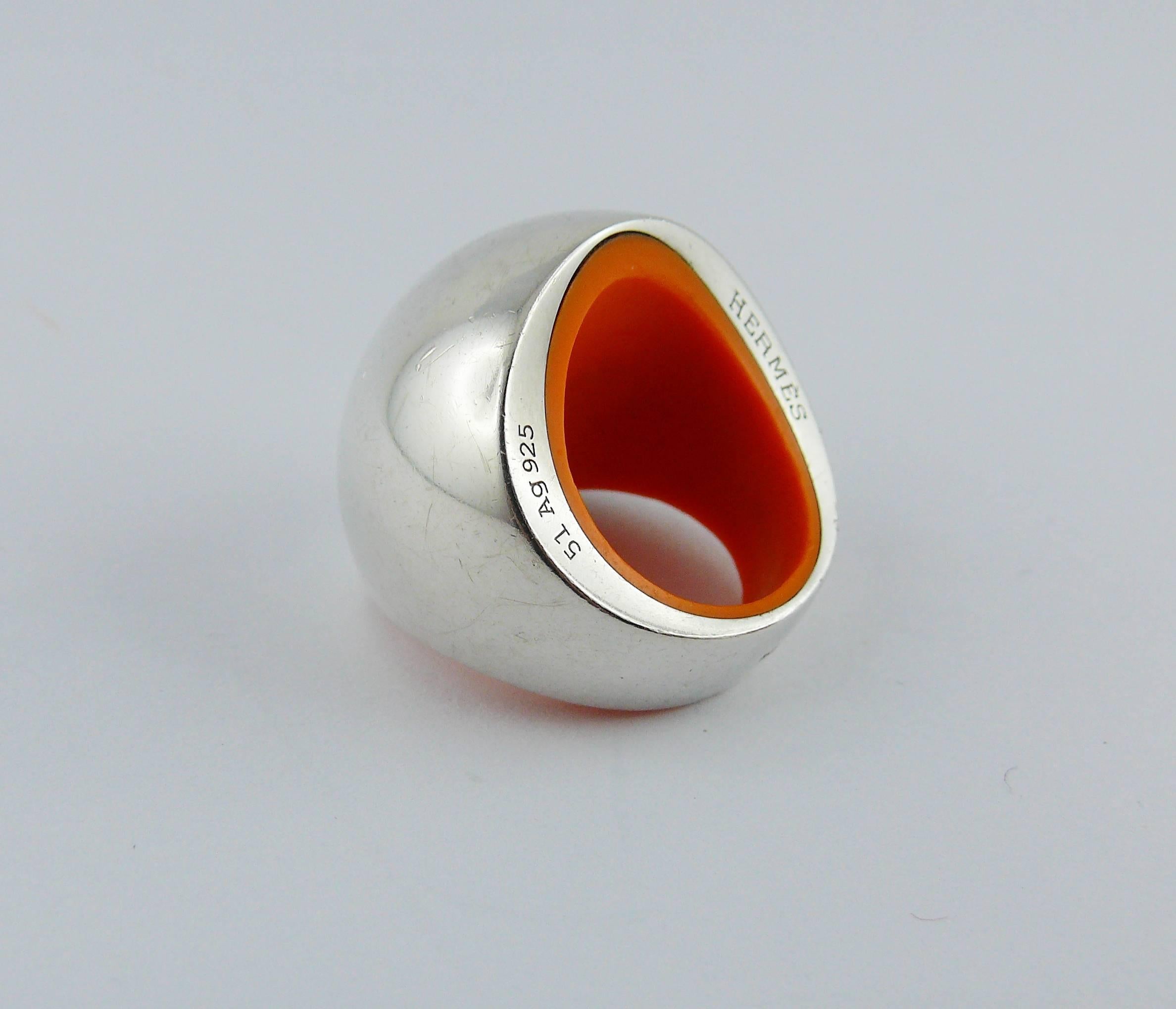 HERMES Ring Quark aus Sterlingsilber mit Kuppelmotiv und orangefarbenem Harzeinsatz.

Prägung HERMES 51 Ag925.
Geprägtes A.D.

Ungefähre Maße: Umfang ca. 5,09 cm (2 Zoll).

Kommt mit Originalverpackung.

ANMERKUNGEN
- Es handelt sich um einen