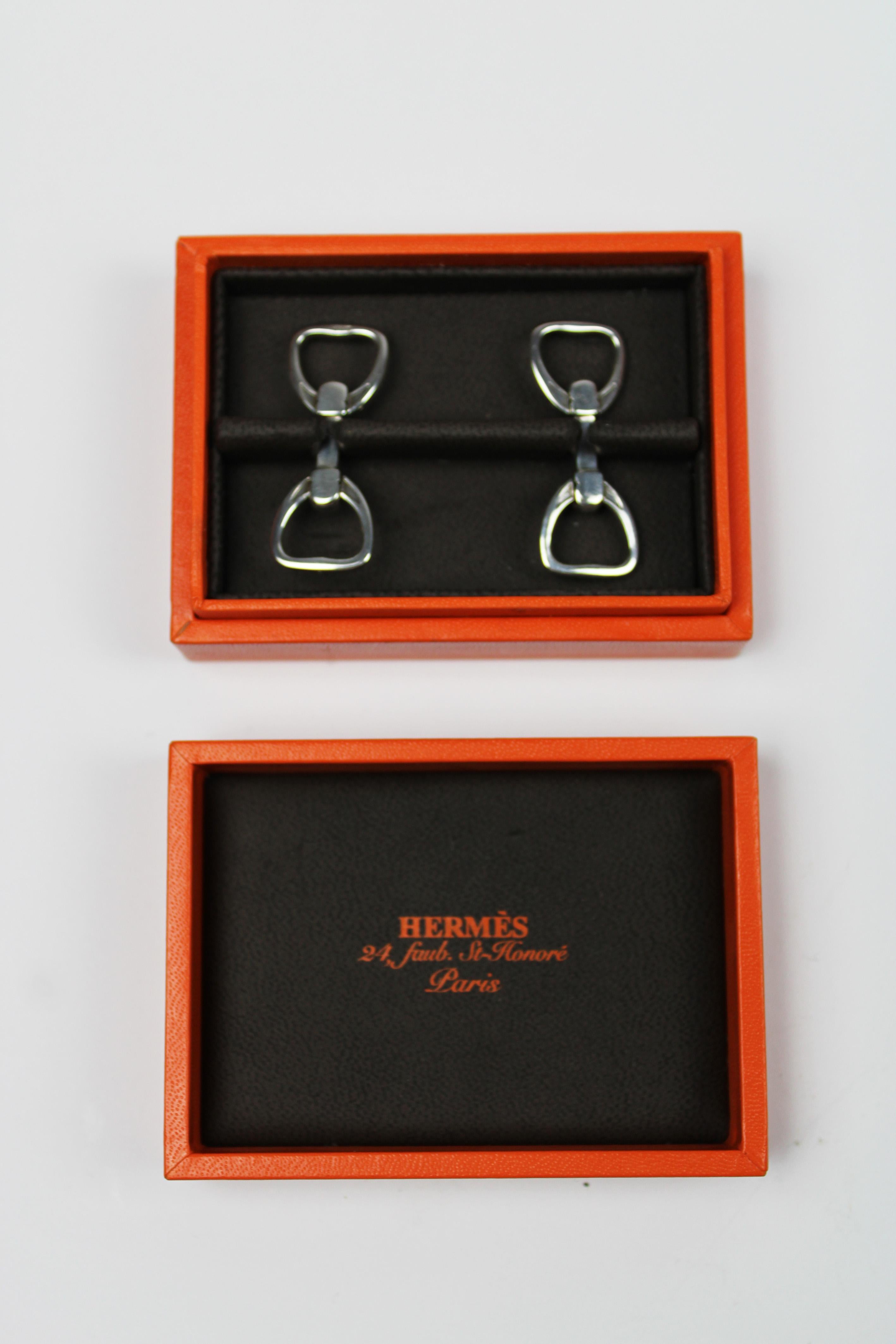 Wir präsentieren ein Paar exquisite Hermès Steigbügelmanschettenknöpfe aus Sterlingsilber, die in der Originalverpackung geliefert werden. Diese Manschettenknöpfe aus dem 21. Jahrhundert verkörpern die zeitlose Eleganz und die sorgfältige