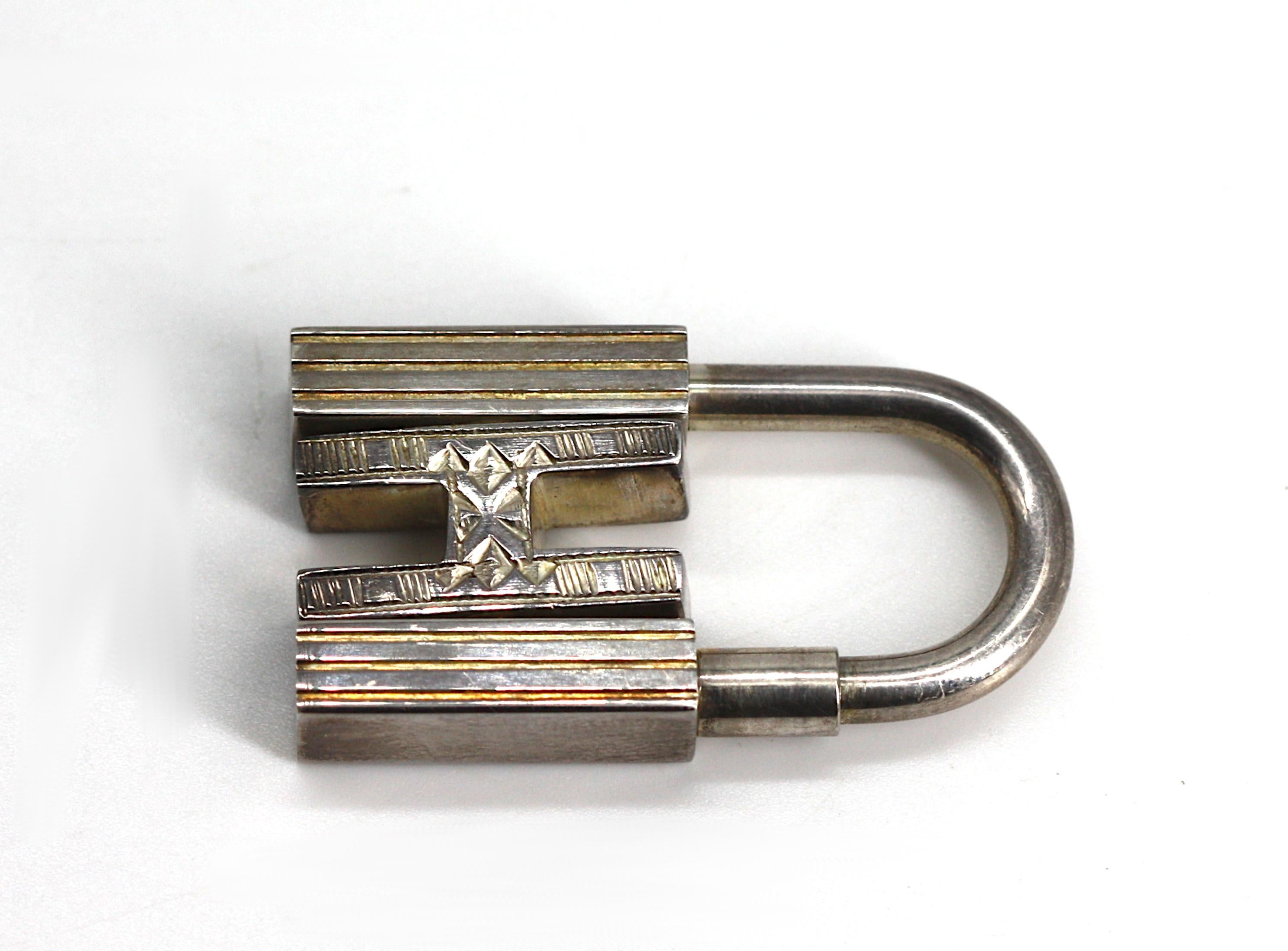 
Hermes Sterling Silver Touareg H Motif Cadena Padlock Bag Charm
Signed Hermes, 925, with another indistinct mark, with ribbon-tied box. Height 1.25 in.
