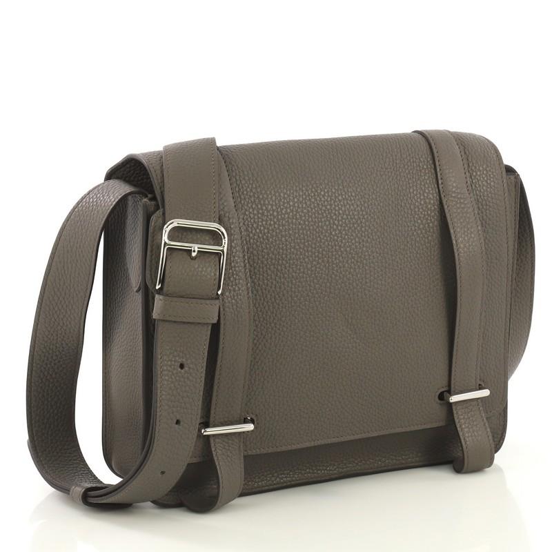 This Hermes Steve Caporal Handbag Clemence, crafted in Etain gray Clemence leather, features an adjustable leather strap and palladium hardware. Its bracket closure opens to an Etain gray Chevre leather interior with slip pocket. Date code reads: X