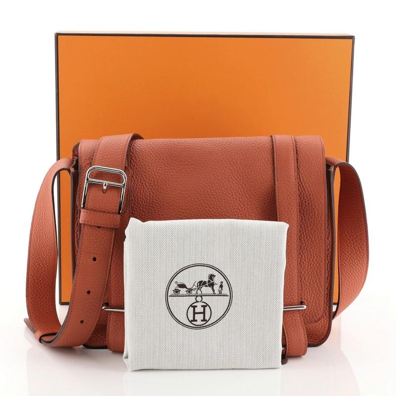This Hermes Steve Caporal Handbag Clemence, crafted in Terre Battue orange Clemence leather, features an adjustable leather strap and palladium hardware. Its bracket closure opens to a Terre Battue orange Chevre leather interior with slip pocket.