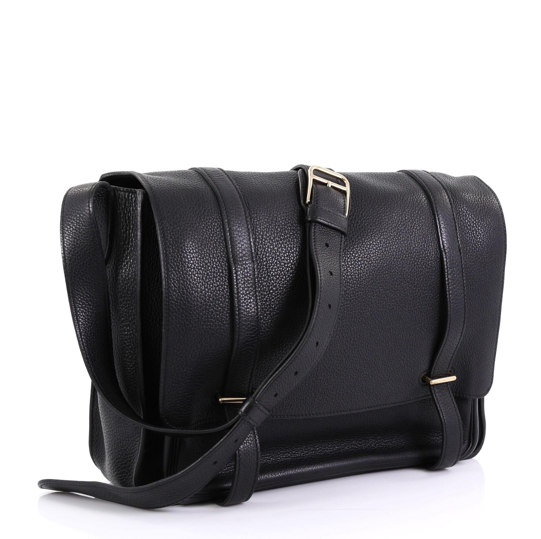This Hermes Steve Messenger Bag Clemence 35, crafted in Noir black Clemence leather, features a frontal flap pocket with double tab and bracket closure, adjustable leather strap, and gold hardware. Its bracket closure opens to a Noir black Chevre