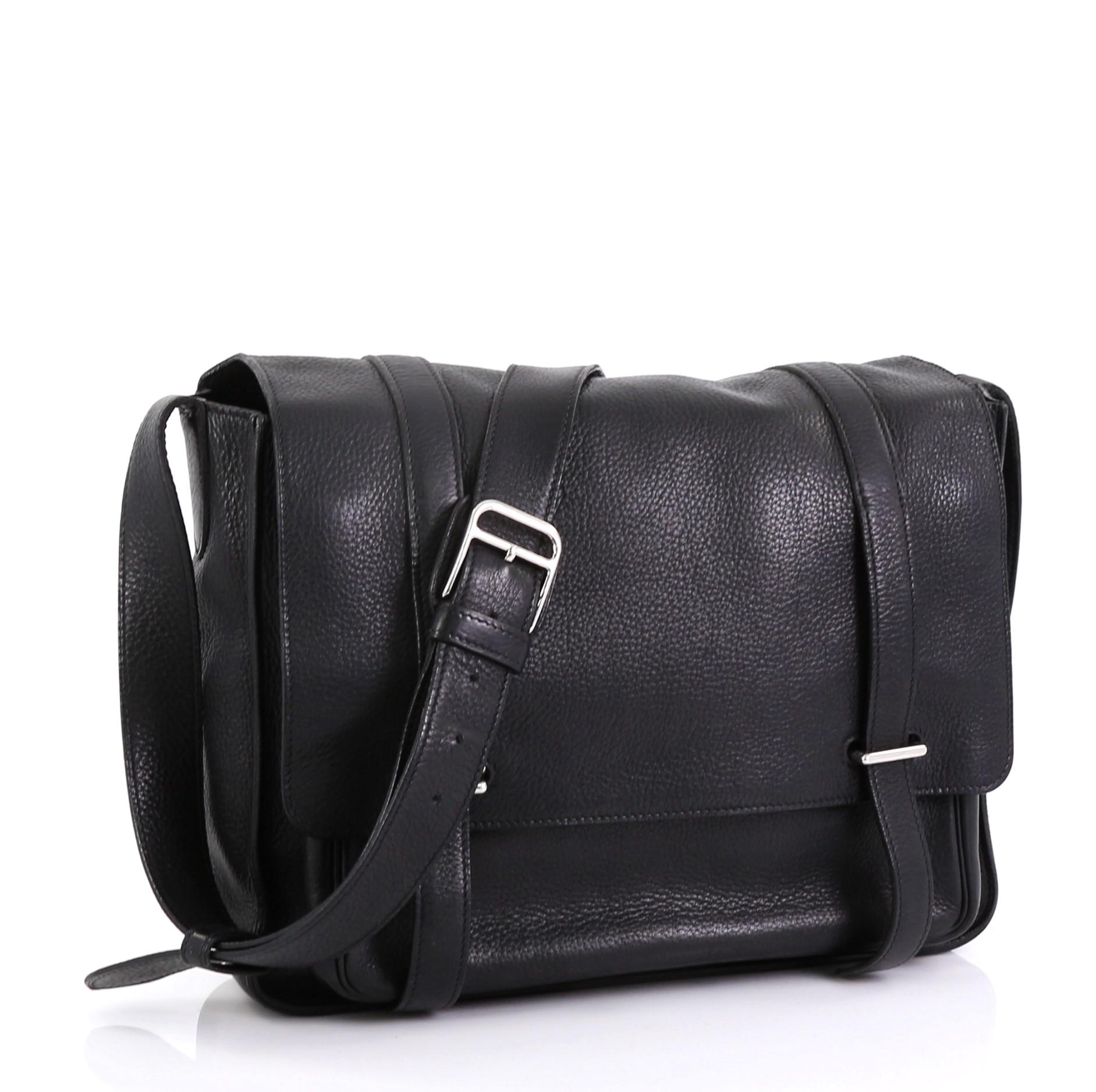 This Hermes Steve Messenger Bag Clemence 35, crafted in Noir black Clemence leather, features a frontal flap pocket with double tab and bracket closure, adjustable leather strap, and palladium hardware. Its bracket closure opens to a Noir black