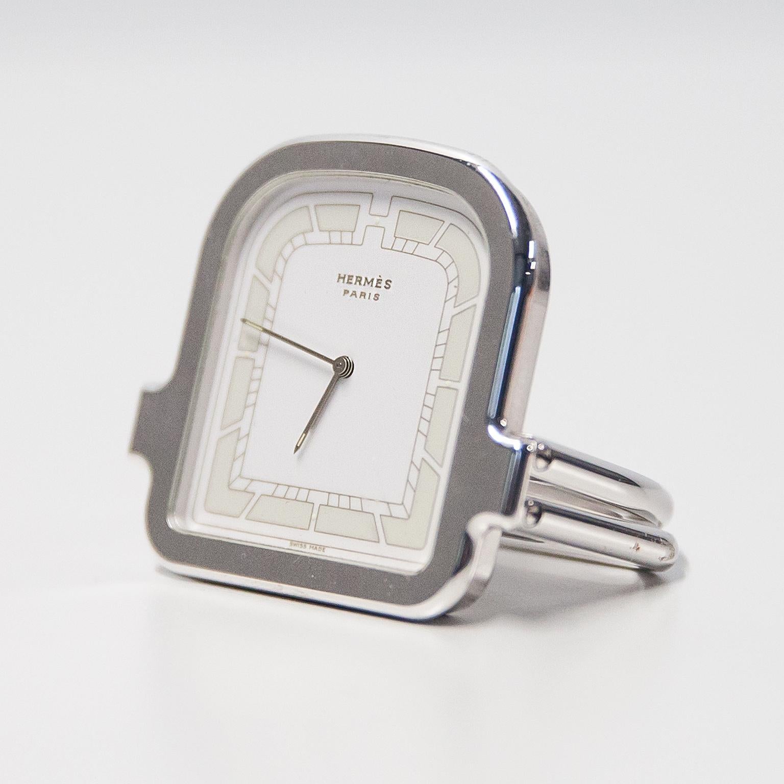 Orologio da viaggio Hermes in metallo argentato, quadrante bianco e beige con movimento al quarzo. Condizioni vintage molto buone nella scatola originale.