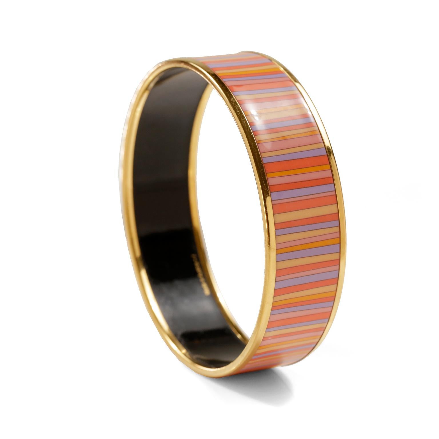 This authentic Hermès Striped Enamel Bracelet is in very good condition.  Gold tone edges, multicolored thin striped pattern in shades of orange, lavender, pink and yellow.  Made in Austria, F stamp.
