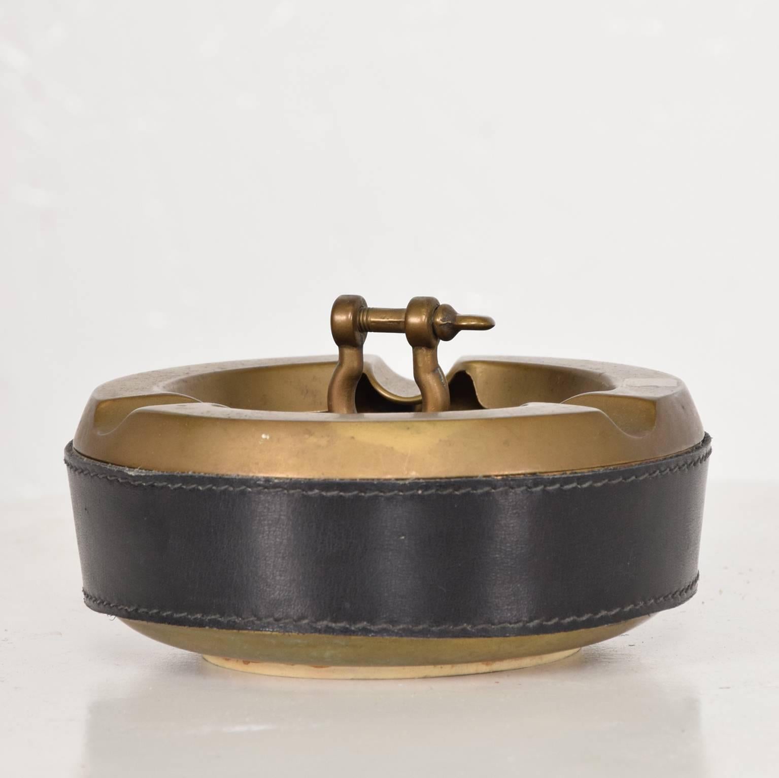For your consideration a beautiful ashtray in solid brass and leather. 
In the style of Hermes.
Italy, 1960s.
 