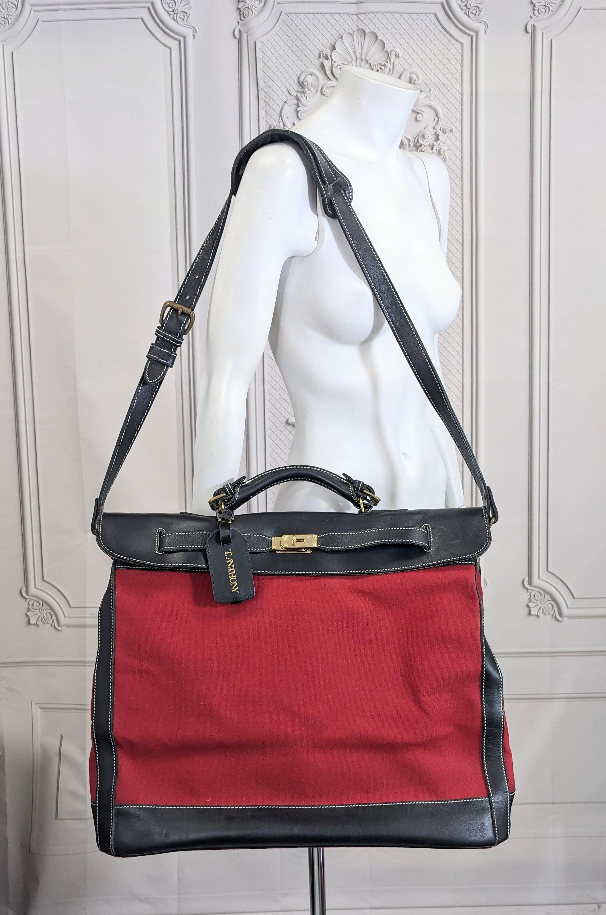 Auffällige Reisetasche aus Leder und Segeltuch im Hermes-Stil von T. Anthony aus den 1990er Jahren. Schwerer roter Baumwollcanvas gepaart mit schwarzem Kalbsleder in dieser übergroßen Reisetasche im Birkin-Stil.
Bitte beachten Sie, dass es sich um
