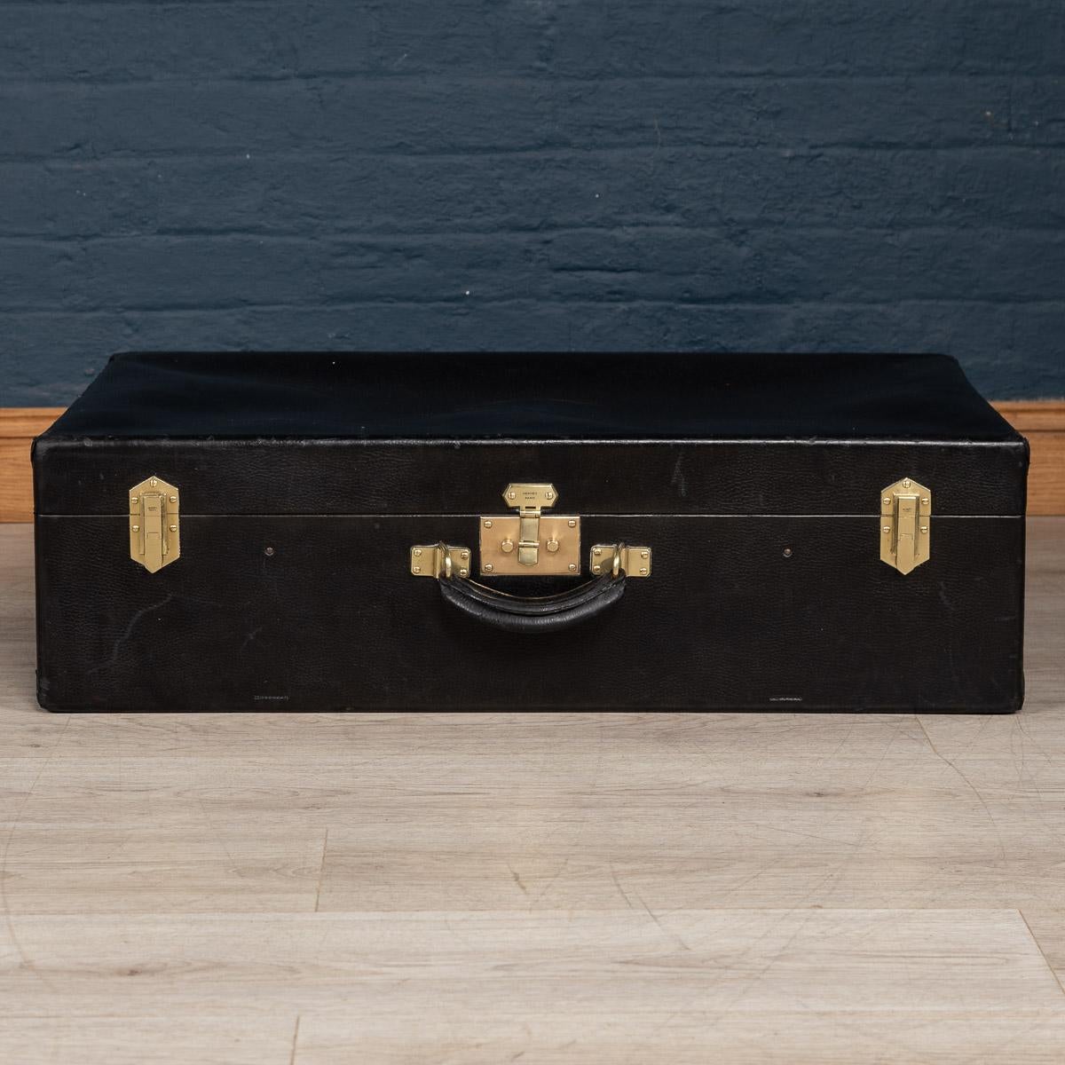 A very rare Hermès suitcase in black leatherette covering and brass locks and side latches, made in France in the first half of the 20th century. A great addition to any collection and a fantastic item to have as part of a stack in any interior