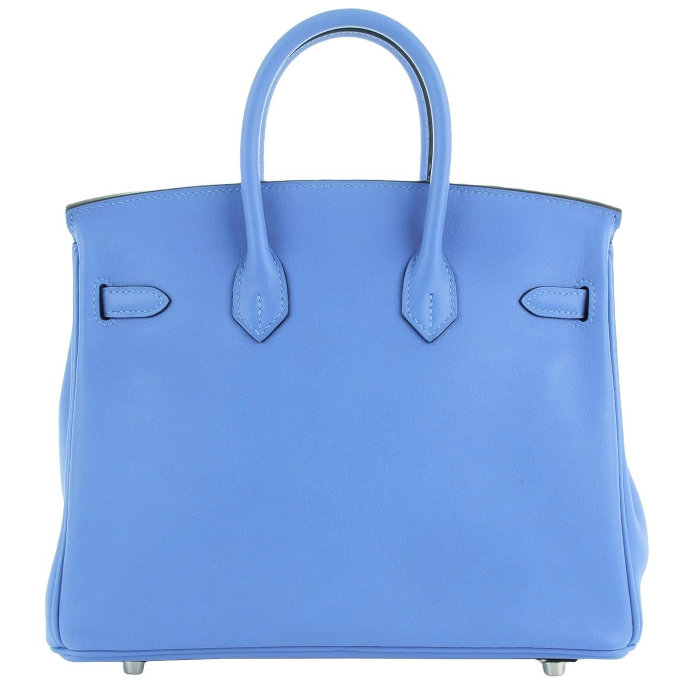 This is an authentic HERMES Swift Birkin 25 in Bleu Paradis. This chic and iconic handbag is expertly handcrafted of luxurious calfskin leather in a vibrant blue. The bag features rolled leather top handles, a front flap, a strap closure, and silver