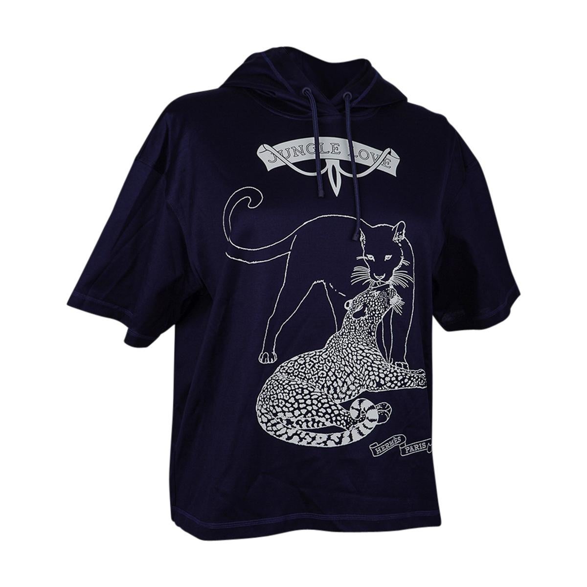 Mightychic offers an Hermes Jungle Love Hooded T-shirt featured in Marine and White.
This beloved Jungle Love print top is in executed in contrast and has a boxy cut with short sleeves.
Hood has braided cord.
Fabric is cotton.
Made in France.
NEW or