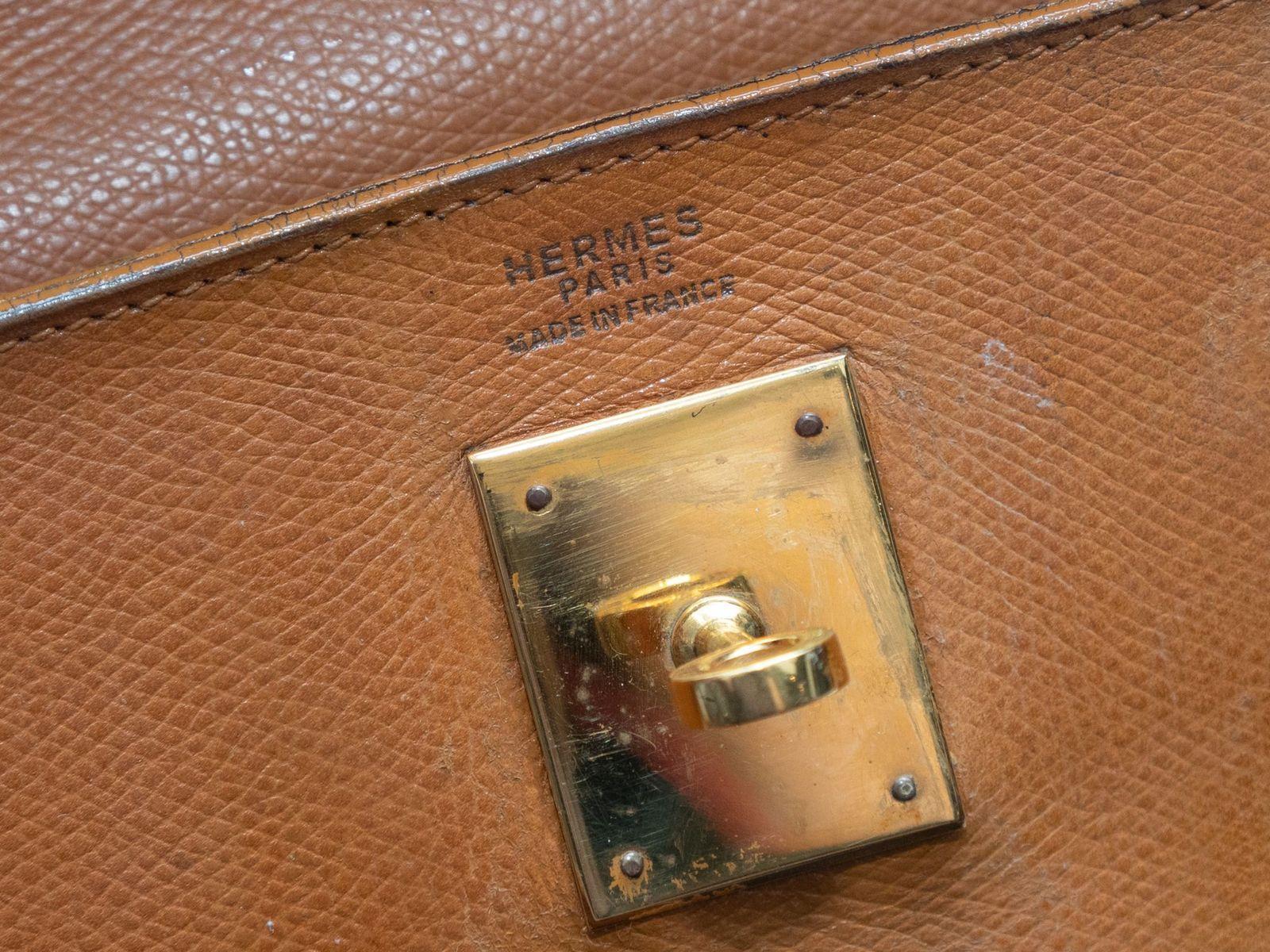 Product Details: Vintage Tan Hermes 1979 Kelly 32 Bag. The Kelly 32 bag features a leather body, gold-tone hardware, single rolled top handle, and front clasp closure. 11.5