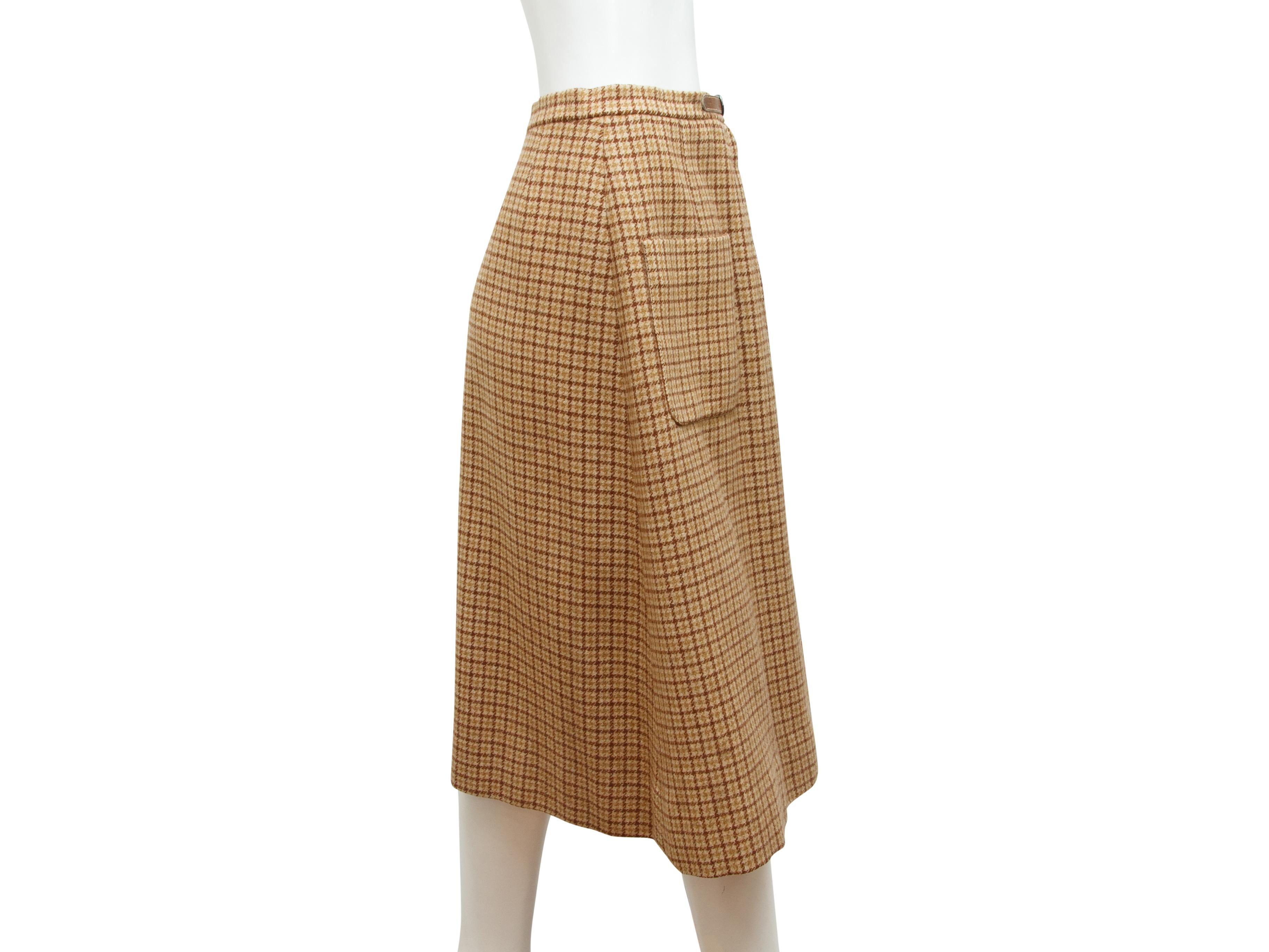 Product details:  Vintage tan wool A-line skirt by Hermes.  Leather belted accent.  Zip-front closure.  Front patch pockets.  Label size FR 42.  30