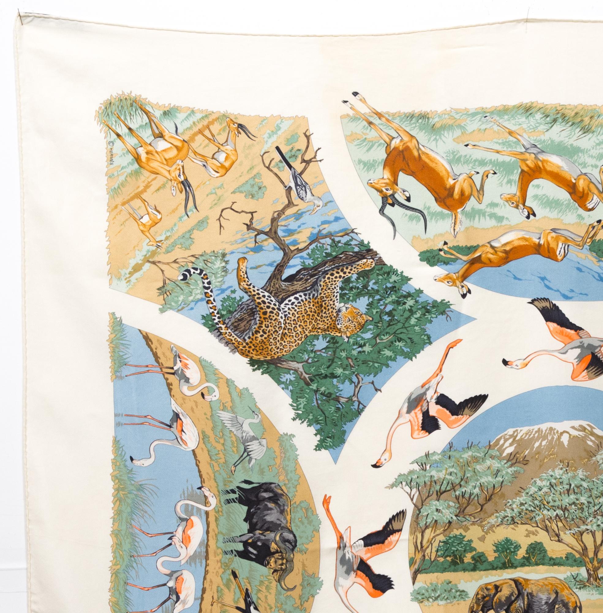 Hermes silk scarf Tanzanie by Robert Dallet featuring an ivory border and a Hermès signature. 
Circa: 1997
In good vintage condition. Made in France.
35,4in. (90cm)  X 35,4in. (90cm)
We guarantee you will receive this  iconic item as described and