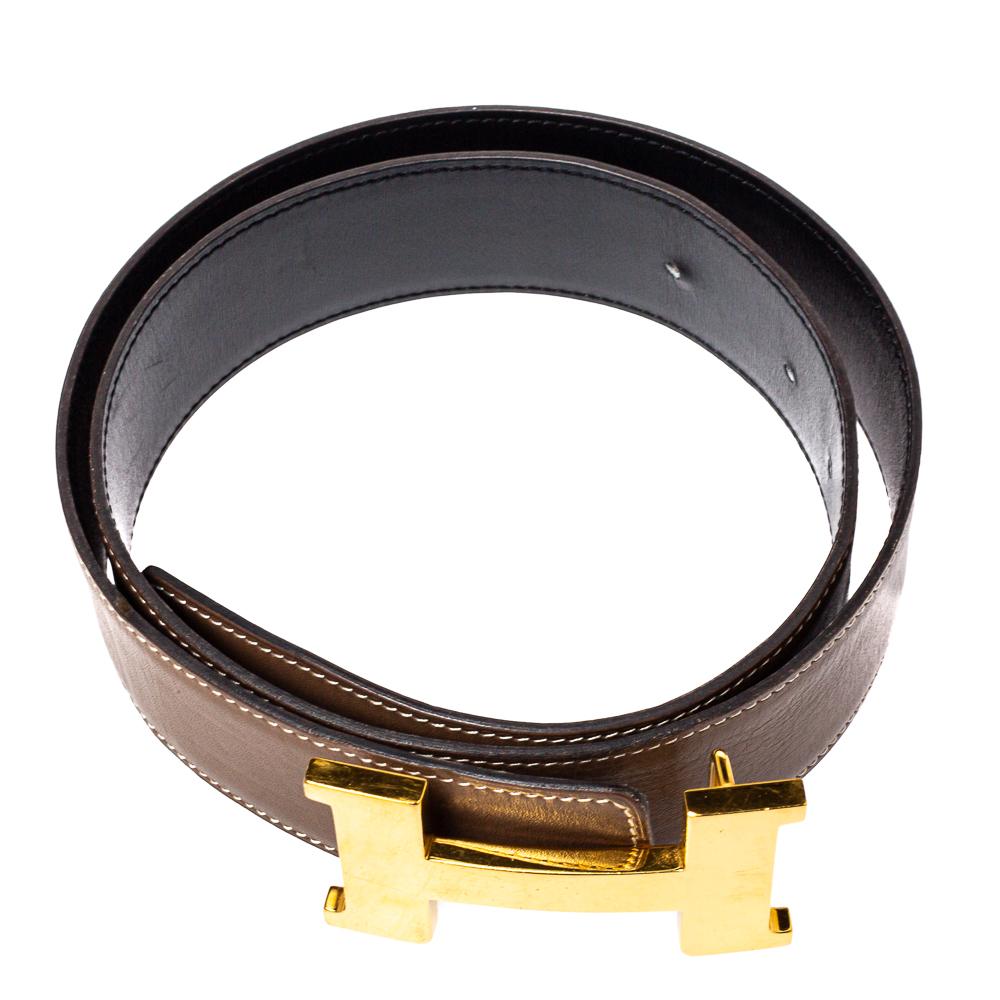 A classic add-on to your collection of belts is this Hermes piece in Swift leather. It is reversible with a taupe shade on one side and black on the other. It is topped with an 'H' buckle in gold-tone hardware. This wardrobe essential piece will