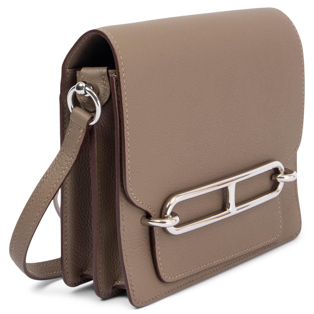 100% authentic Hermes Roulis 18 Mini shoulder bag in Etoupe (taupe) Veau Evercolor leather with palladium hardware. Open pocket on the outside back. Interior is divided in to two compartments by a full size open pocket. Lined in Chevre (goat skin)