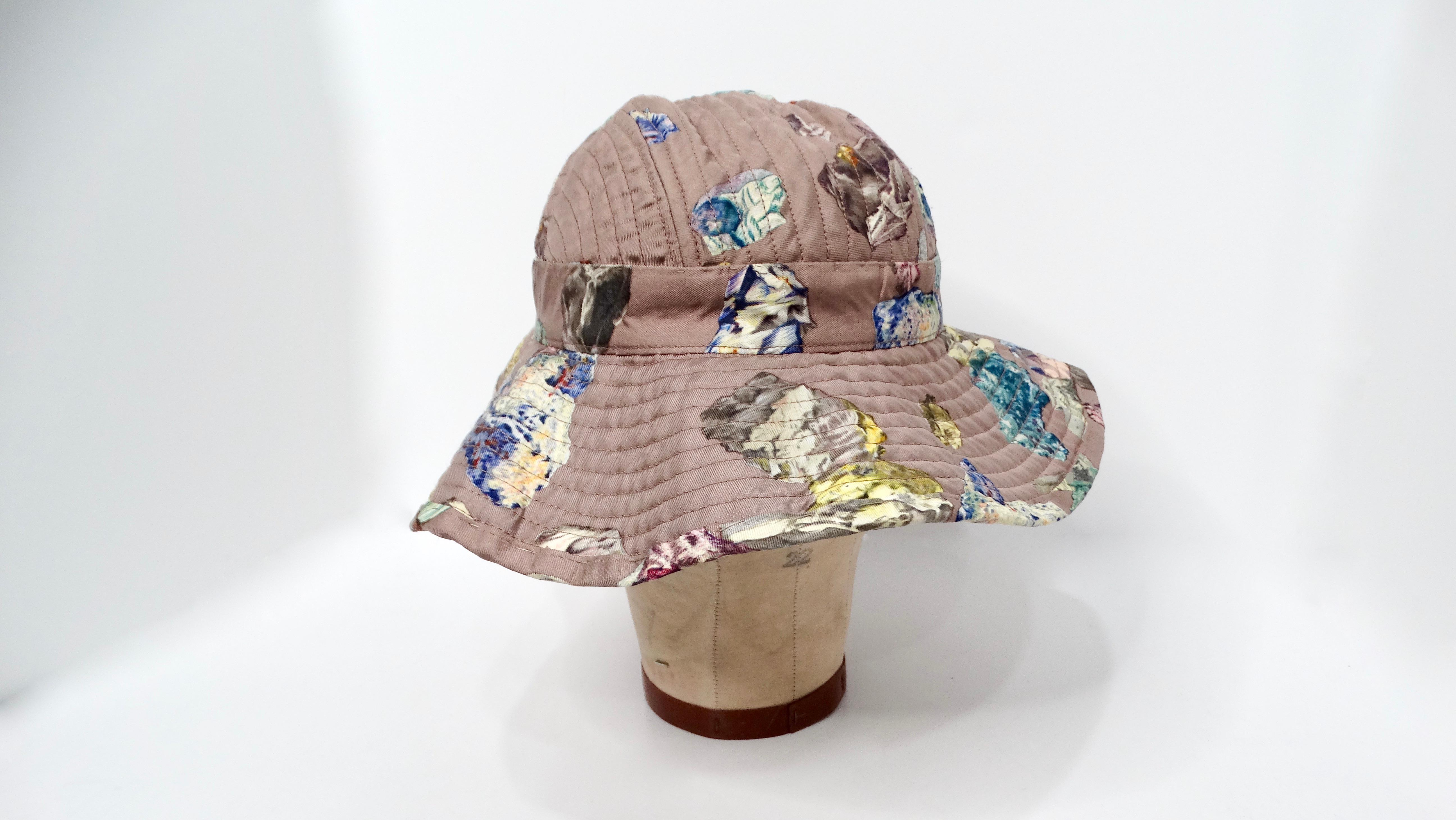 The Hermes Taupe Geo Rock & Crystal Print Silk Sun Hat exudes elegance and sophistication, making it a standout accessory for any fashion-forward individual. Featuring a taupe base adorned with a striking print of colorful rocks and crystals, this