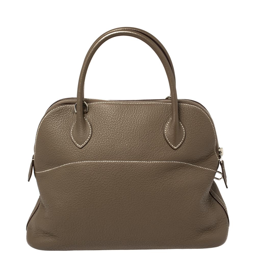Luxuriously crafted by the experts at Hermes, this stunning Bolide 31 bag is a must-have accessory for fashion lovers. An apt everyday wear bag, it is the perfect combination of sophistication and practicality. Crafted from Clemence leather, this