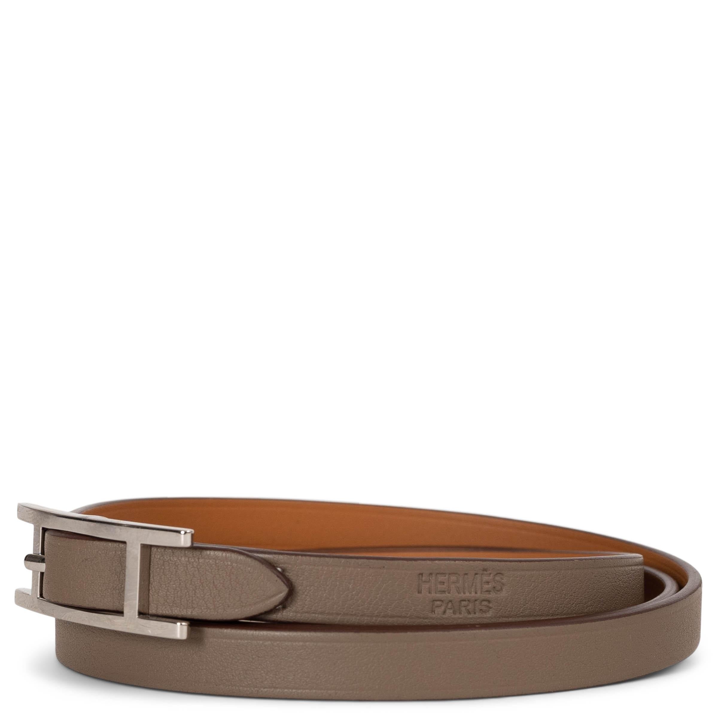 This 100% authentic Hermès Hapi Reversible Double Tour strap bracelet is crafted from luxurious Swift calfskin and features the emblematic Hapi clasp. Designed with versatility in mind, its reversible construction allows you to effortlessly switch
