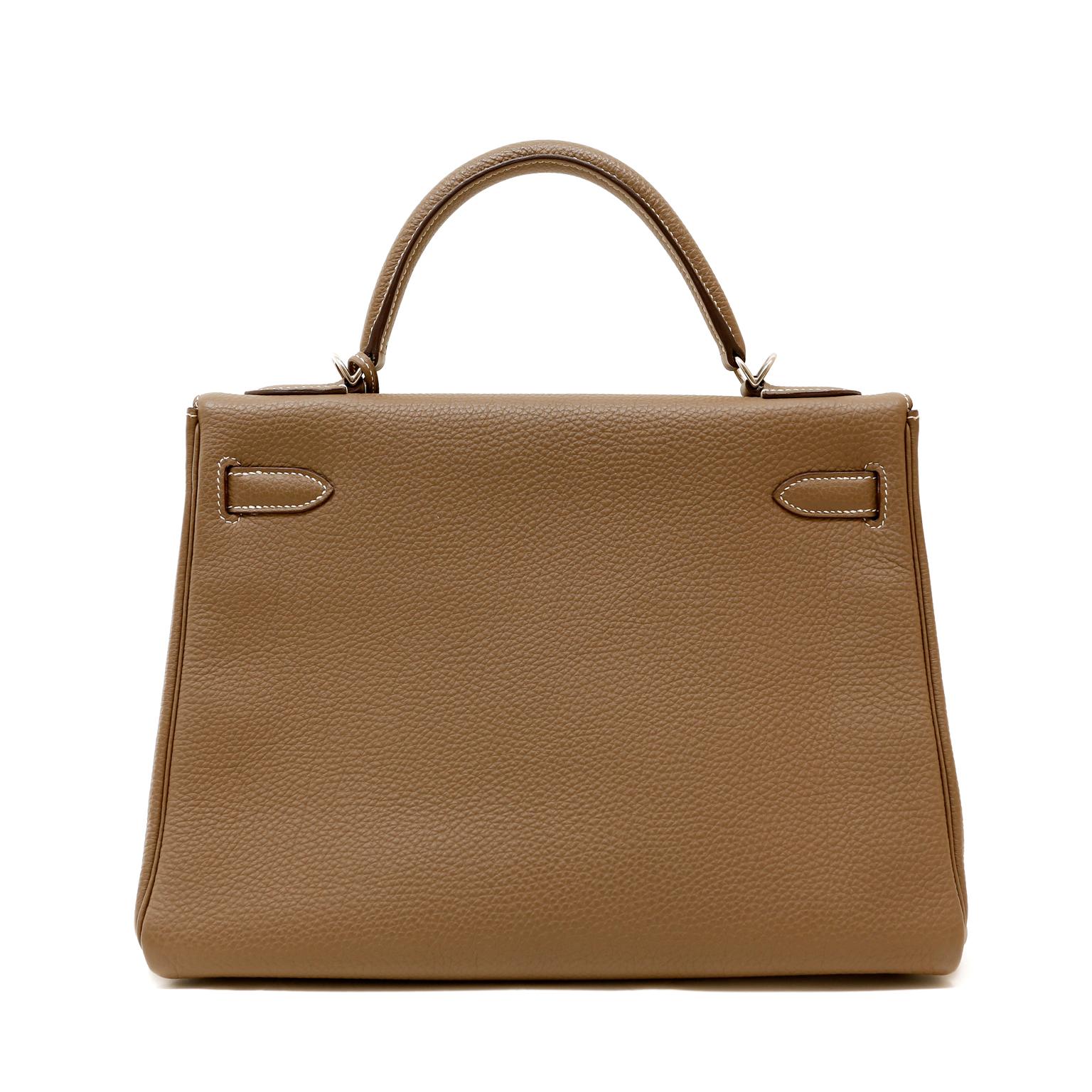 This authentic Hermès Taupe Togo Leather 32 cm Kelly is in excellent condition.  The ladylike Kelly is in high demand and requires extensive waiting periods from Hermès.  Neutral taupe paired with Palladium hardware is a classic addition to any