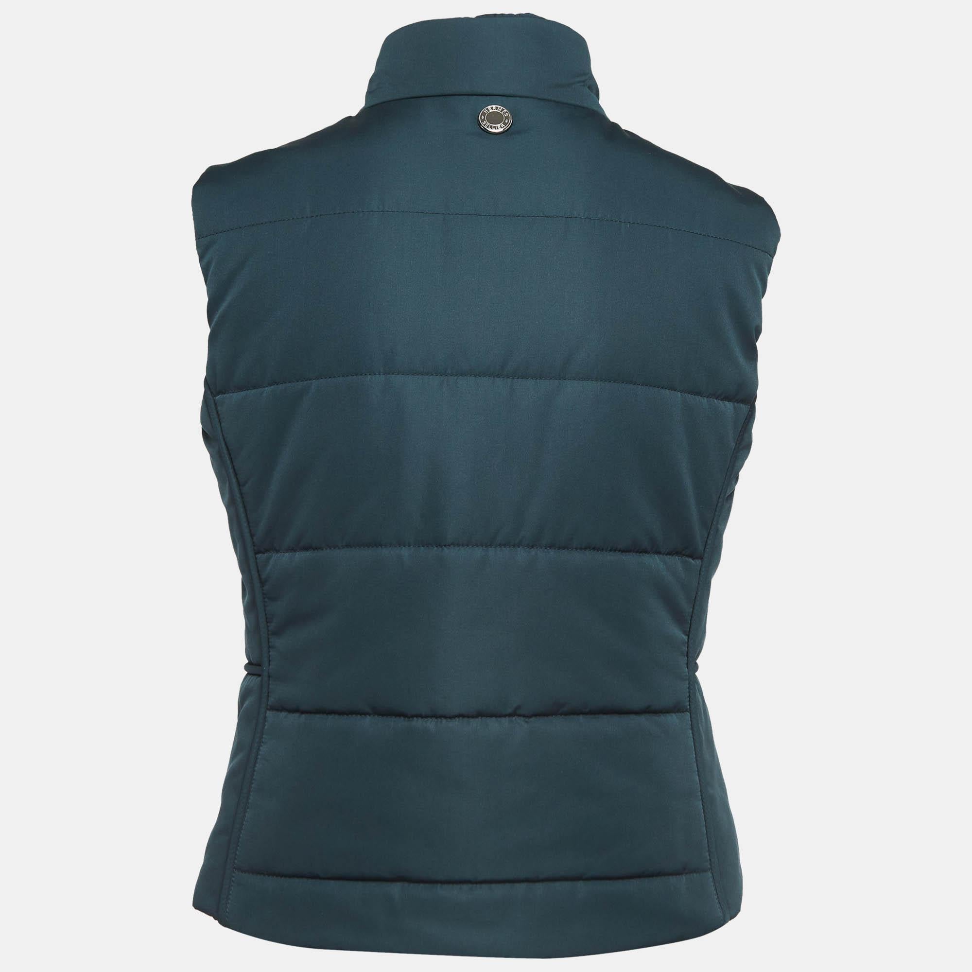 Wrap yourself in the refined luxury of the Hermès vest. Crafted with precision and finesse, this vest boasts a sleek silhouette and quilted design. Its vibrant teal hue adds a pop of color to any ensemble, while the sleeveless cut offers versatility