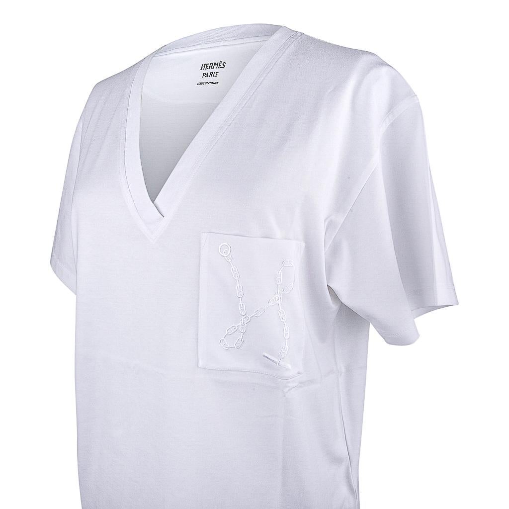 Guaranteed authentic Hermes White Embroidered Pocket Straight T-shirt.
Chaine d'Ancre embroidered on Pocket.
V-neck with short sleeve.
Classic style and effortless elegance.
Fabric is cotton. 
NEW or NEVER WORN.  
final sale 

SIZE  40
USA SIZE 