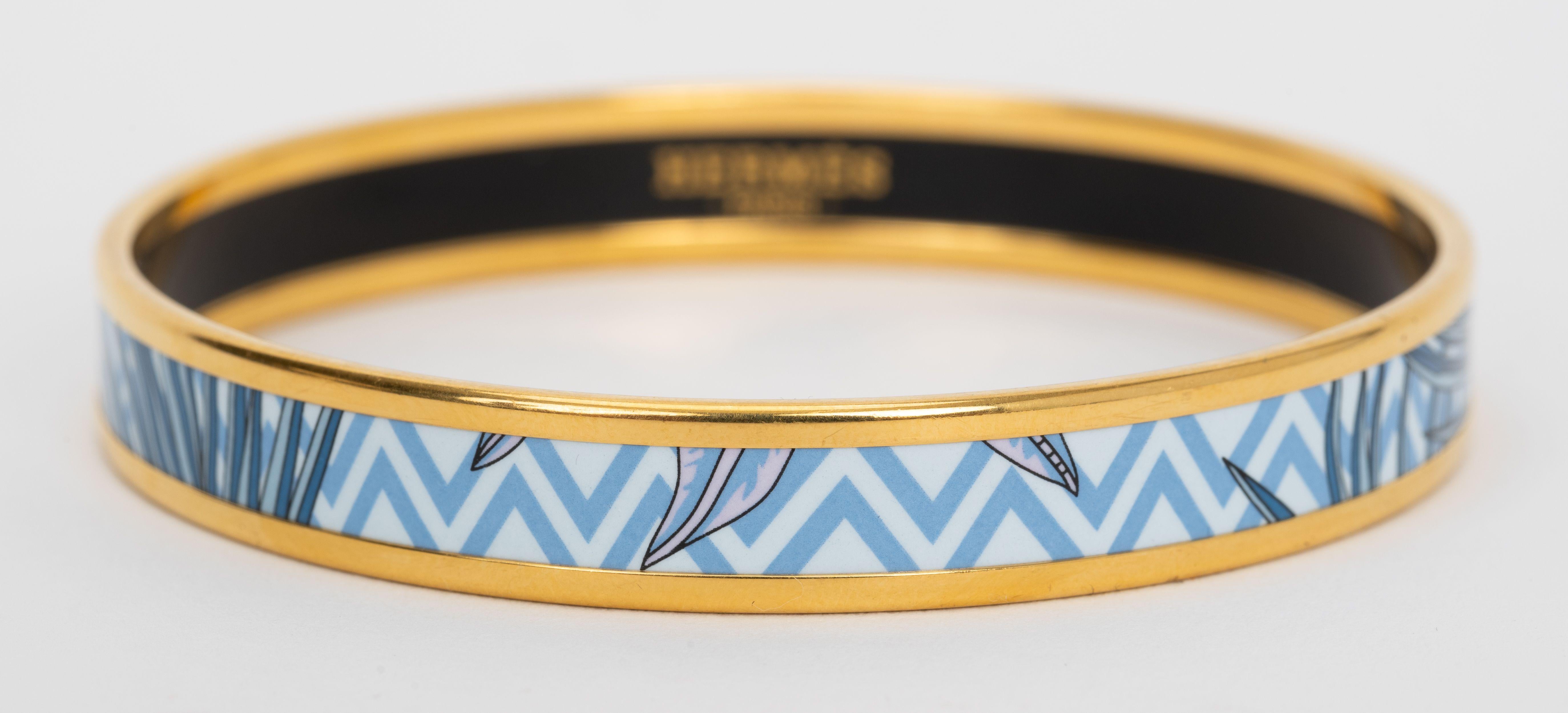 Hermes printed blue feathers enamel bangle with gold plated hardware. The bracelet is perfect for stacking.