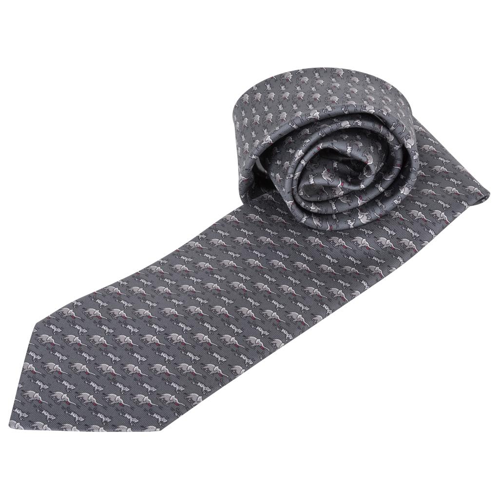 Guaranteed authentic Hermes tie features Sauve Qui Peut ! Twillbi.
Gris Fonce and Gris color way.
Charming depiction of an elephant in the game of cat-and-mouse.
Designed by Philippe Mouquet.
NEW or NEVER WORN
Comes with signature Hermes box. 
final