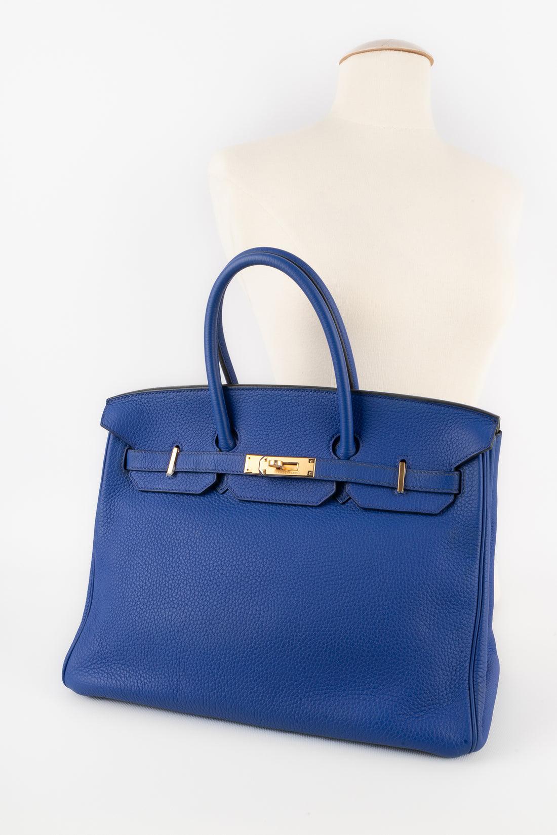 Hermès - (Made in France) 35 cm Togo calfskin 'Birkin' bag in an electric-blue color. Gold-plated ties and fastener. Double handle, keys under a tiny cloche, and padlock. Piece with a certificate of conformity. A 2011 collection.

Additional