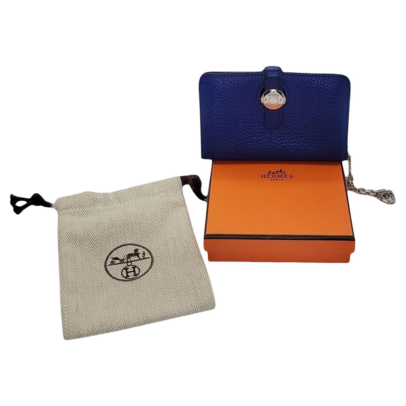 Offrez-vous le luxe avec le porte-cartes Togo Dogon d'Hermès. Fabriqué en cuir Togo bleu électrique de première qualité, cet étui à cartes chic est à la fois souple et durable. Son compartiment unique se fixe à l'aide d'une élégante sangle et d'une