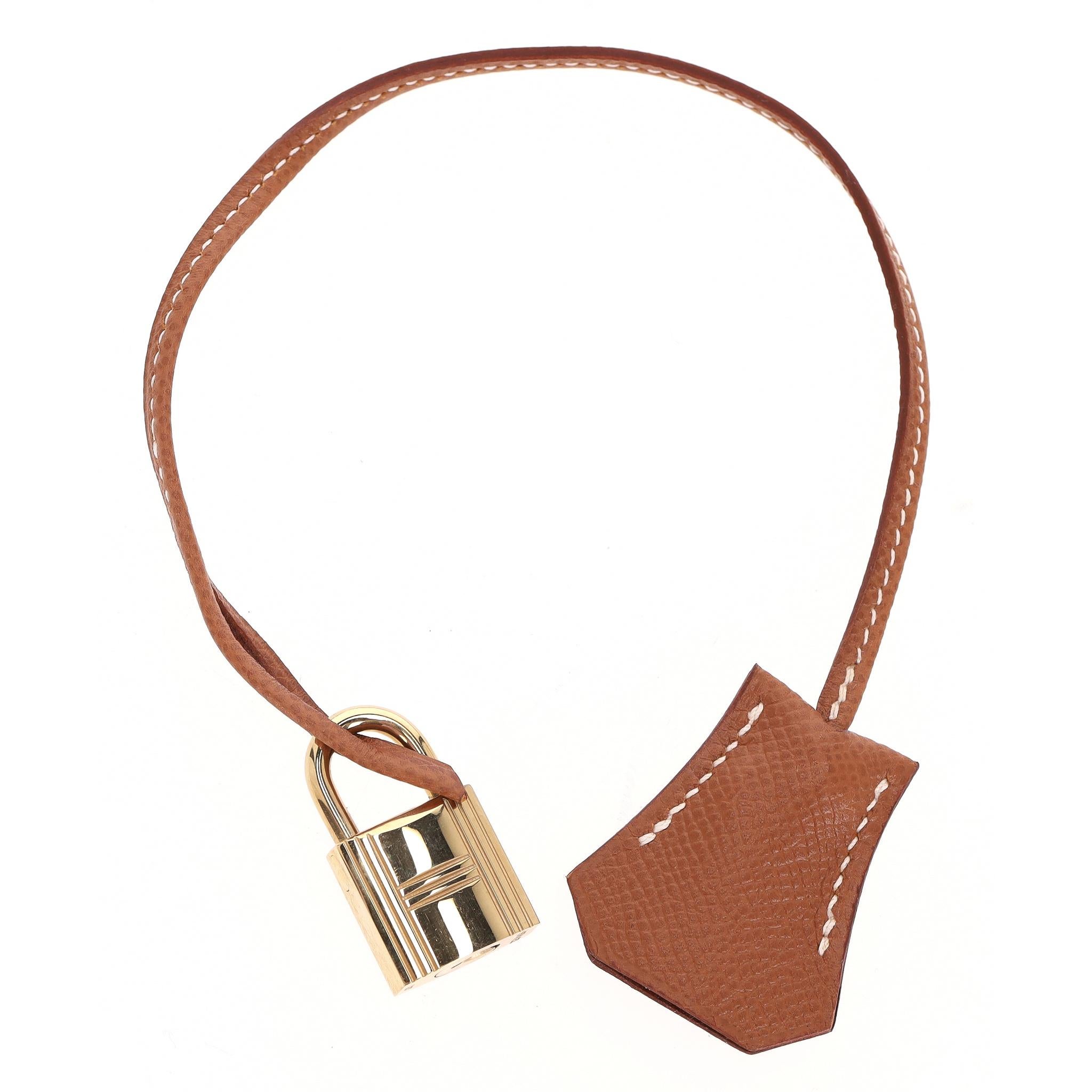 Set di Clochette, Lucchetto e Chiavi in Pelle Togo di Hermes

Clochette in pelle dorata con cuciture bianche a contrasto, lucchetto e chiavi dorate - accessori che si abbinano alle borse Hermes come la Birkin o la Kelly.

Il lucchetto può essere