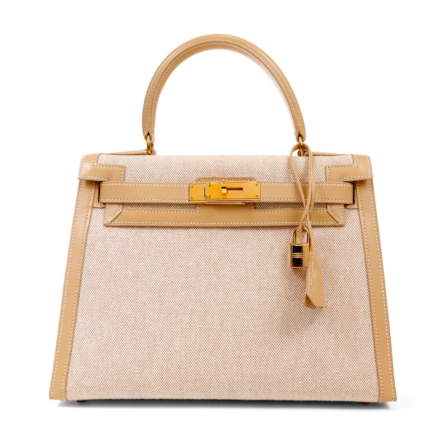 This authentic Hermès Toile and Swift Leather 28 cm Kelly is in pristine condition.  Hermès bags are considered the ultimate luxury item worldwide.  Each piece is hand sewn with waitlists that can exceed a year or more.  This is a rare version of