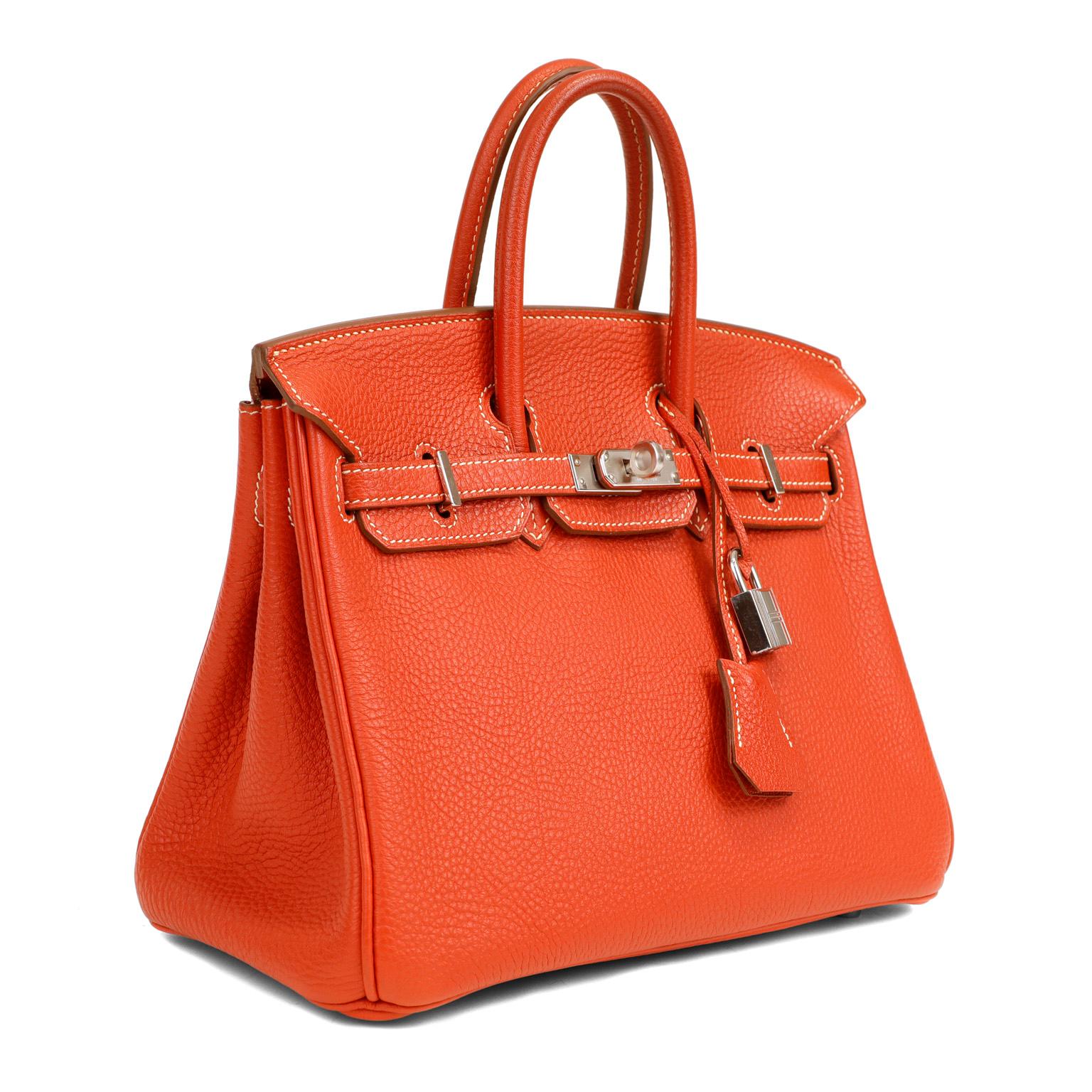 This authentic Hermès Tomato Red 25 cm Birkin is in pristine condition with the protective plastic on much of the hardware.   Hand stitched by skilled craftsmen, wait lists of a year or more are common for the Hermès Birkin. They are considered the