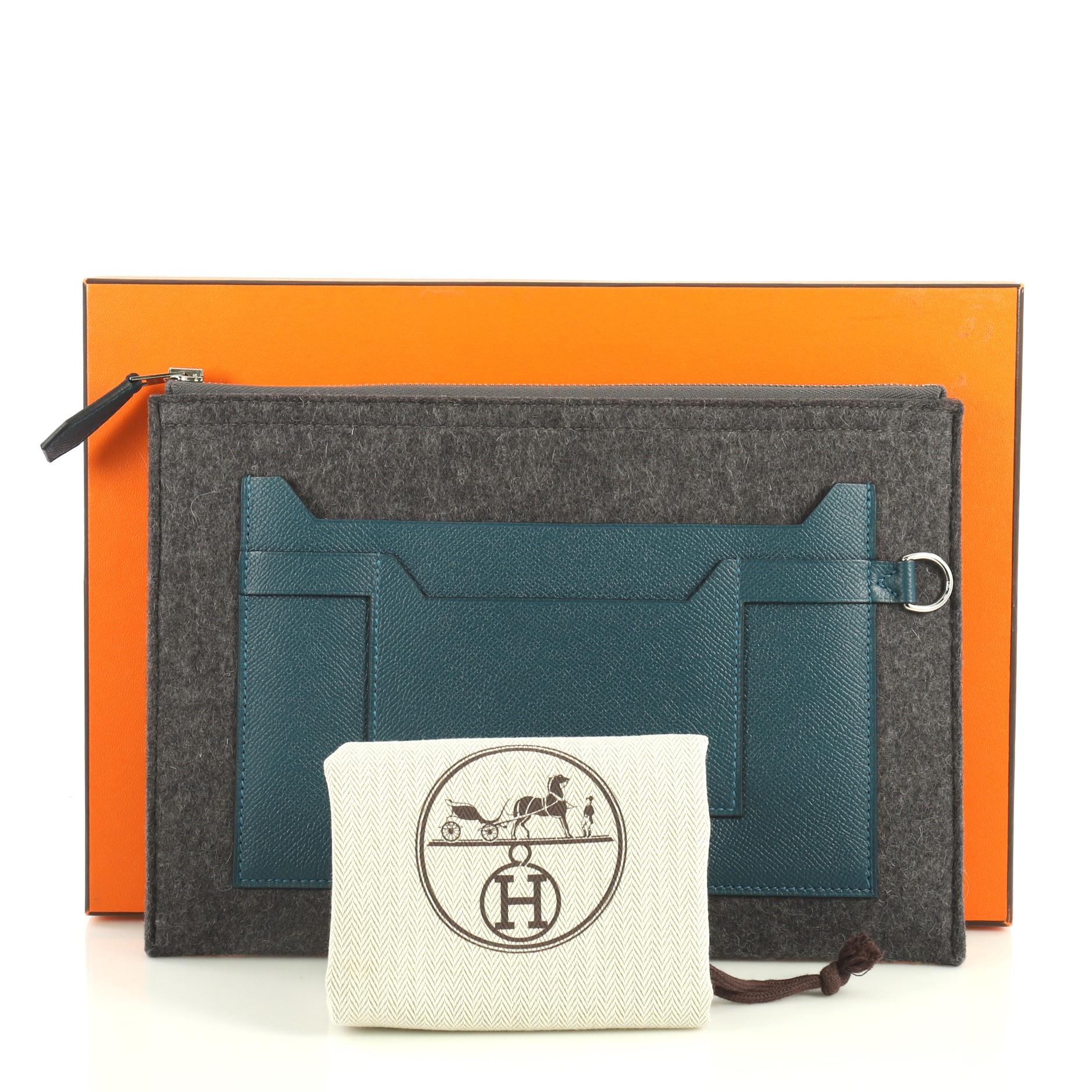 This Hermes Toodoo Pouch Epsom and Wool 29, crafted from Gris Moyen gray Feutre and Colvert blue Epsom leather, features exterior patch pockets and palladium hardware. Its zip closure opens to a Gris Moyen gray Feutre interior. Date stamp reads: A