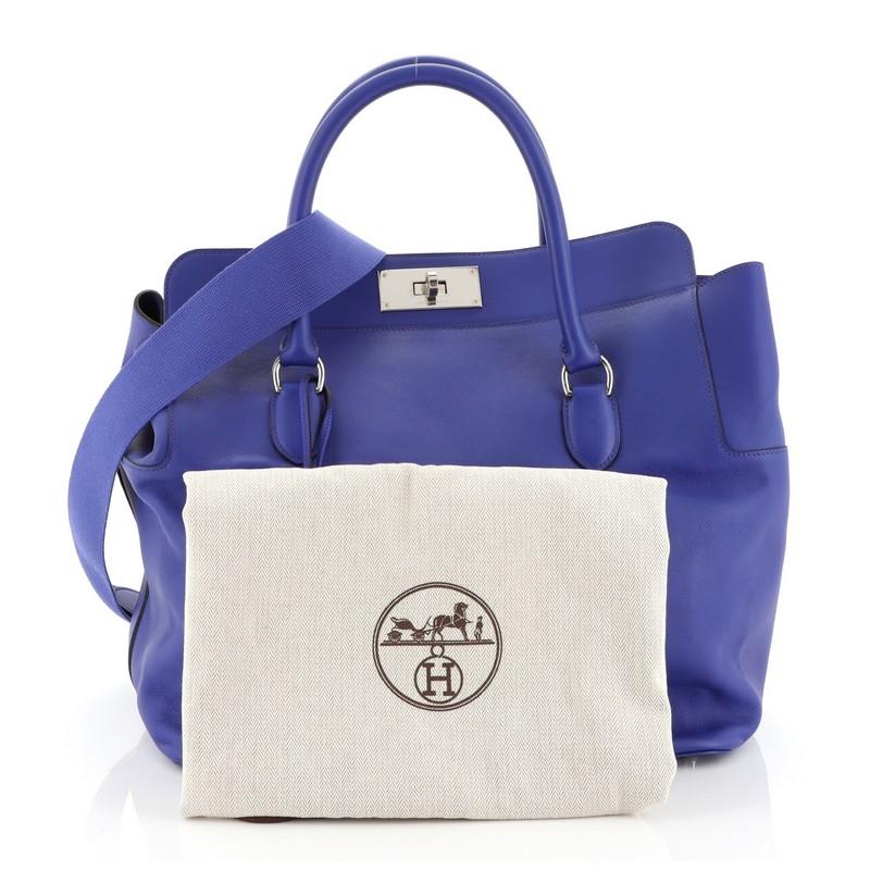 This Hermes Toolbox Handbag Swift 33, crafted from Bleu Electrique blue Swift leather, features dual rolled handles, soft framed top, and palladium hardware. Its turn-lock closure opens to a neutral fabric interior with slip pockets. Date stamp