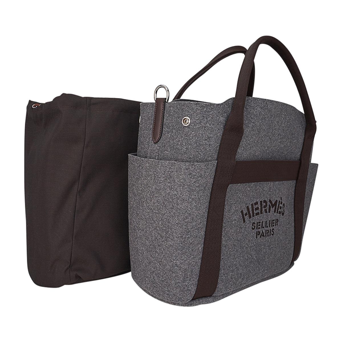 Mightychic offers an Hermes Sac De Pansage Grooming Bag tote featured in Grey Feutre with Brown interior and Palladium hardware.
Hermes Sellier Paris printed on the front.
This versatile tote bag has brown handles, trim and brown shoulder