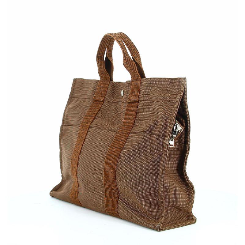 Hermes Toto bag Brown

Very good condition, shows some wear with time.
Brown canvas bag with brown and black stripes that creates the emblem 