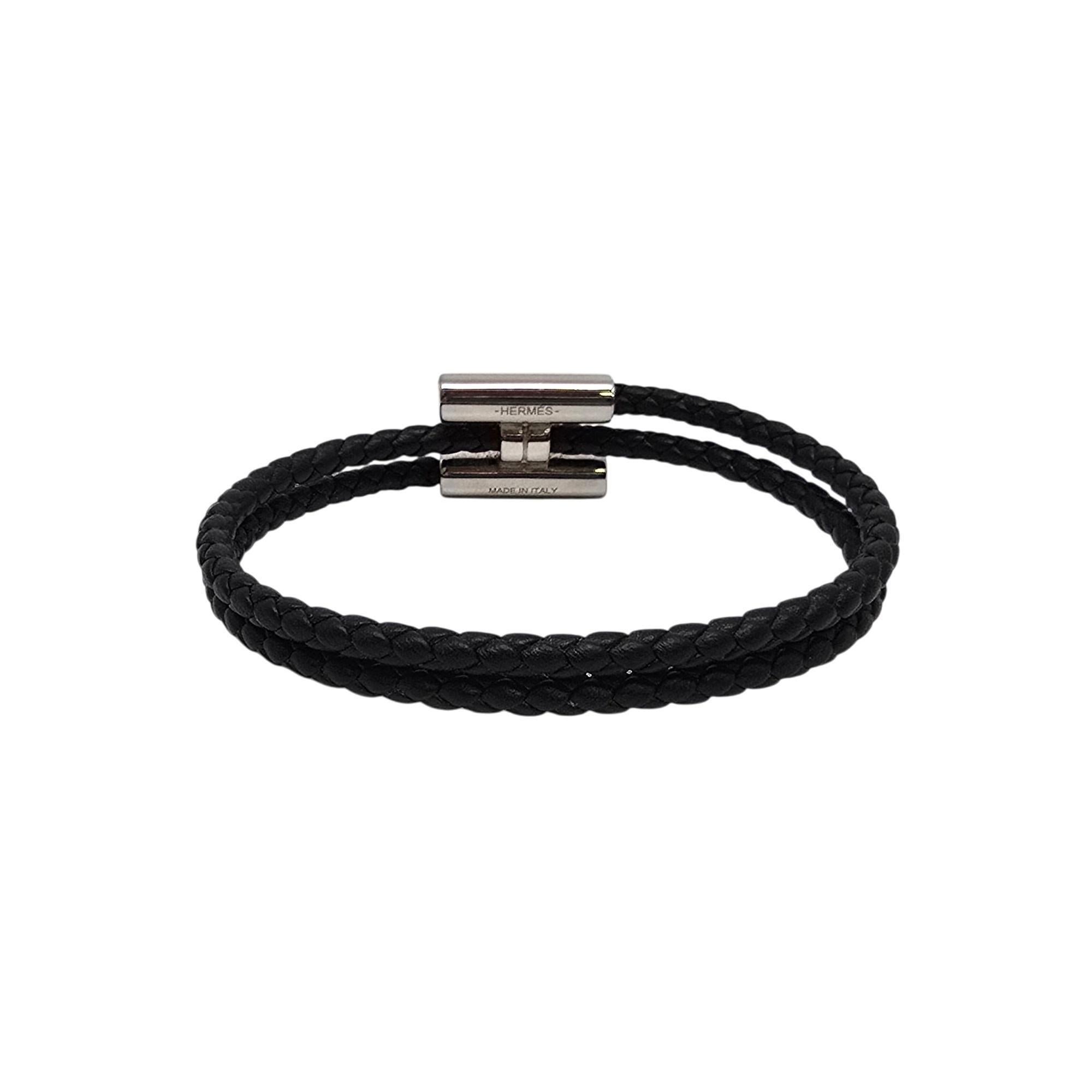Hermes Tournis Tresse bracelet in Noir, with box and pouch.

Palladium plated H clasp on a black Swift calfskin braided wrap around bracelet. This bracelet showcases the House's iconic leather braiding. Includes original Hermes box and